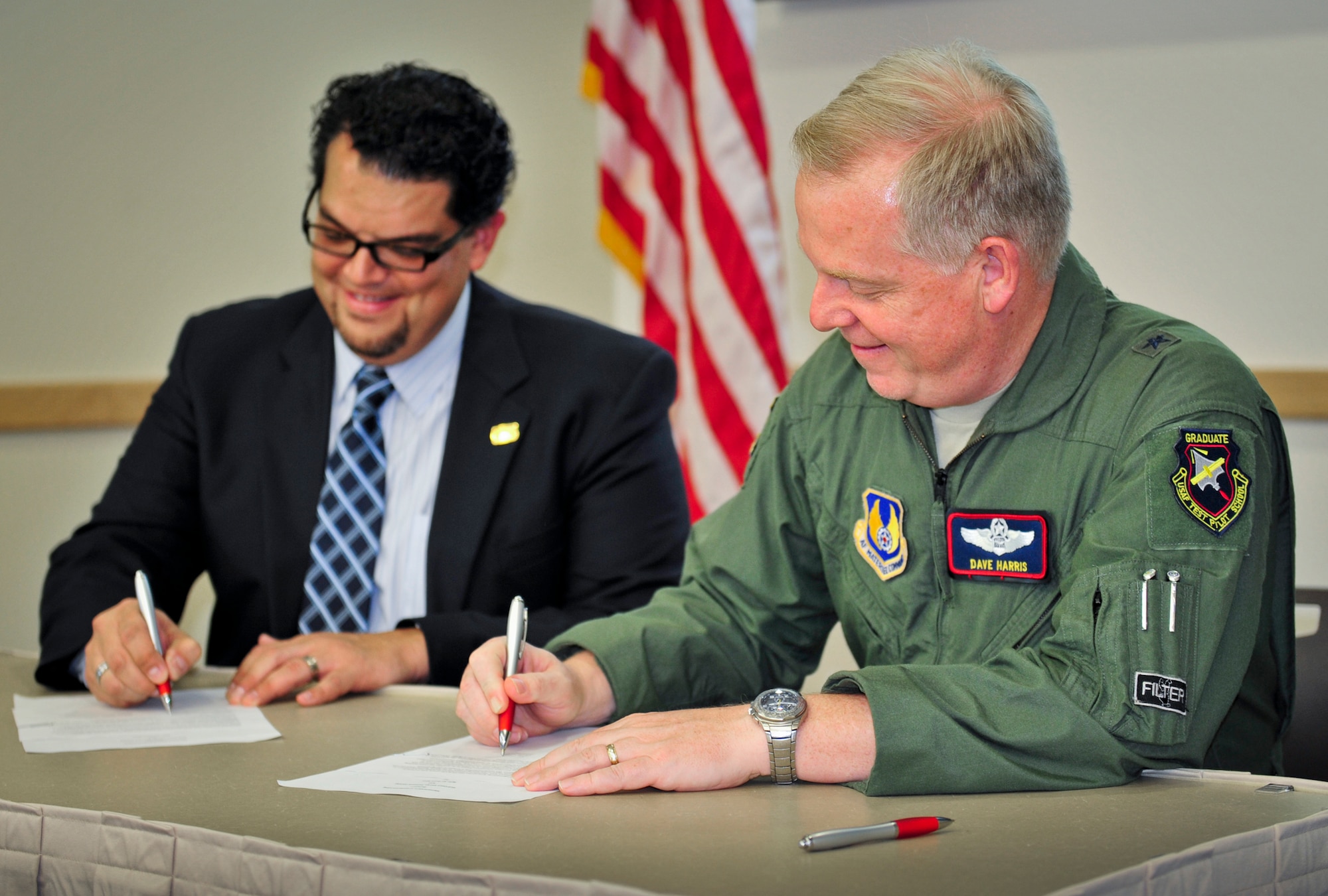 Dave Robau, executive director of the Gulf Coast Energy Network and Brig. Gen. David Harris, 96th Test Wing commander sign a memorandum of agreement between the community and the base for an Eglin Energy Resource and Innovation Partnership during the Community Partnership Program meeting Oct. 1 at Northwest Florida State College. This initiative will help Eglin reach its goal to reduce facility energy intensity 37.5 percent by fiscal year 2020 and increase electricity generated with renewables 25 percent by fiscal year 2025. In collaboration with the Economic Development Council of Okaloosa County, the base is developing partnerships with public or private entities in the areas of research, education, training and installation support for sustainable energy programs and energy conservation measures. (U.S. Air Force photo/Chrissy Cuttita)