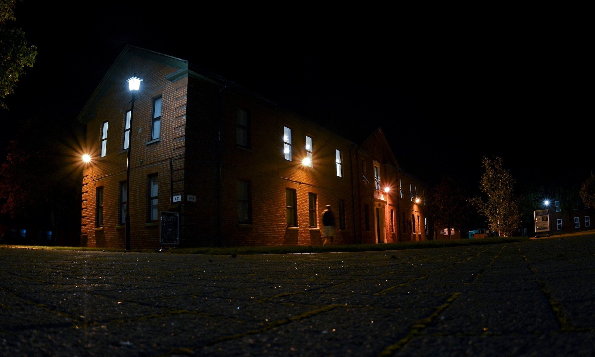 A Team Mildenhall member walks toward the 100th Comptroller Squadron building Sept. 30, 2014, on RAF Mildenhall, England. Airmen from the 100th CPTS worked past normal duty hours for the end of fiscal year 2014 closeout. Each year the Air Force receives funding for defense related expenditures that must be allocated by Sept. 30. Any residual funding from purchases goes back into the allotted amount so it can be used toward other mission essential purchases. (U.S. Air Force photo/Staff Sgt. Micaiah Anthony/Released)