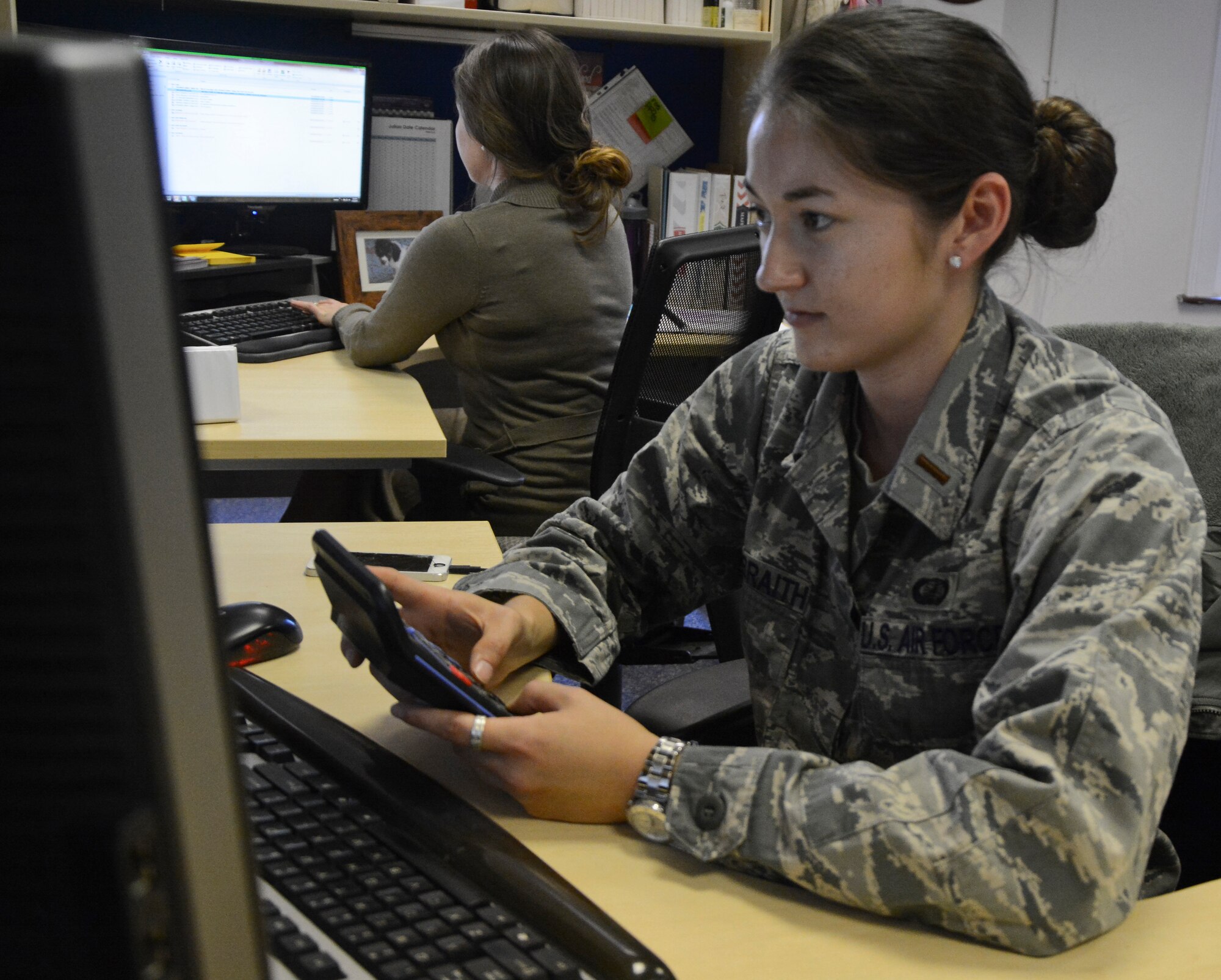 U.S. Air Force 2nd Lt. Virginia Galbraith, 100th Comptroller Squadron financial analysis flight supervisor from Fairfield, Calif., calculates numbers Sept. 30, 2014, on RAF Mildenhall, England. Airmen from the 100th CPTS worked past normal duty hours for the end of fiscal year 2014 closeout. (U.S. Air Force photo/Staff Sgt. Micaiah Anthony/Released)