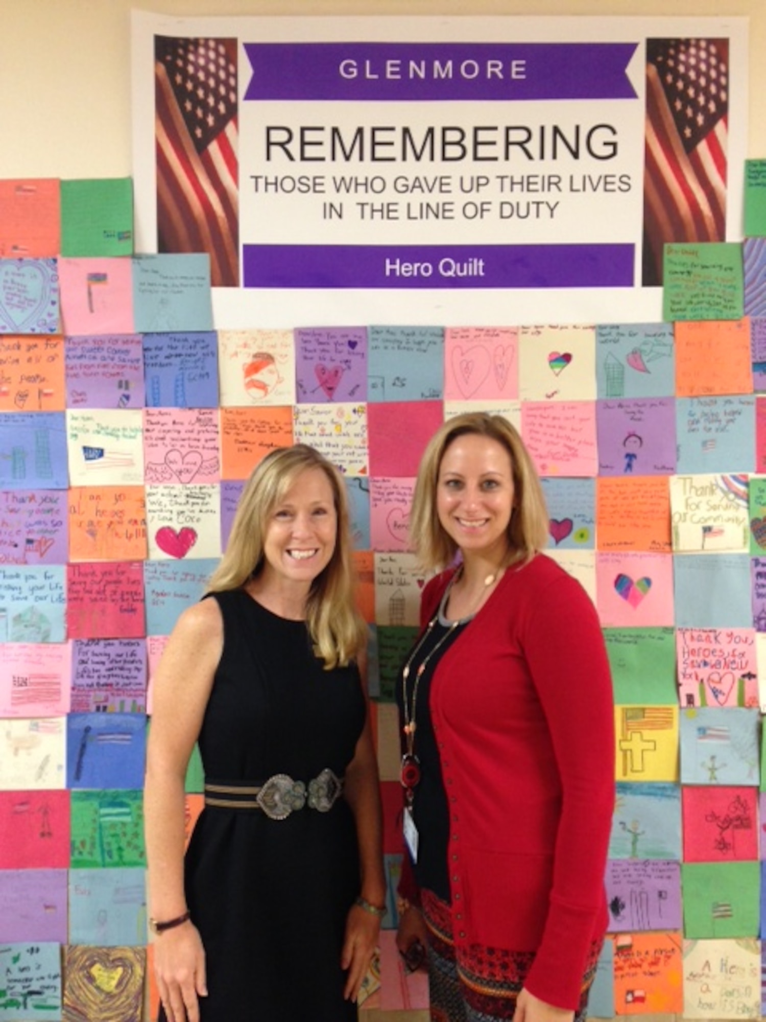 SAN ANGELO, Texas – Debra L. Scougall, Goodfellow Air Force Base school liaison officer, and Nicole Smith, Glenmore Elementary School librarian, pose in front of the “Hero Quilt” at Glenmore Elementary Sept. 30. The quilt was made by first through fifth grade students. (Courtesy photo)