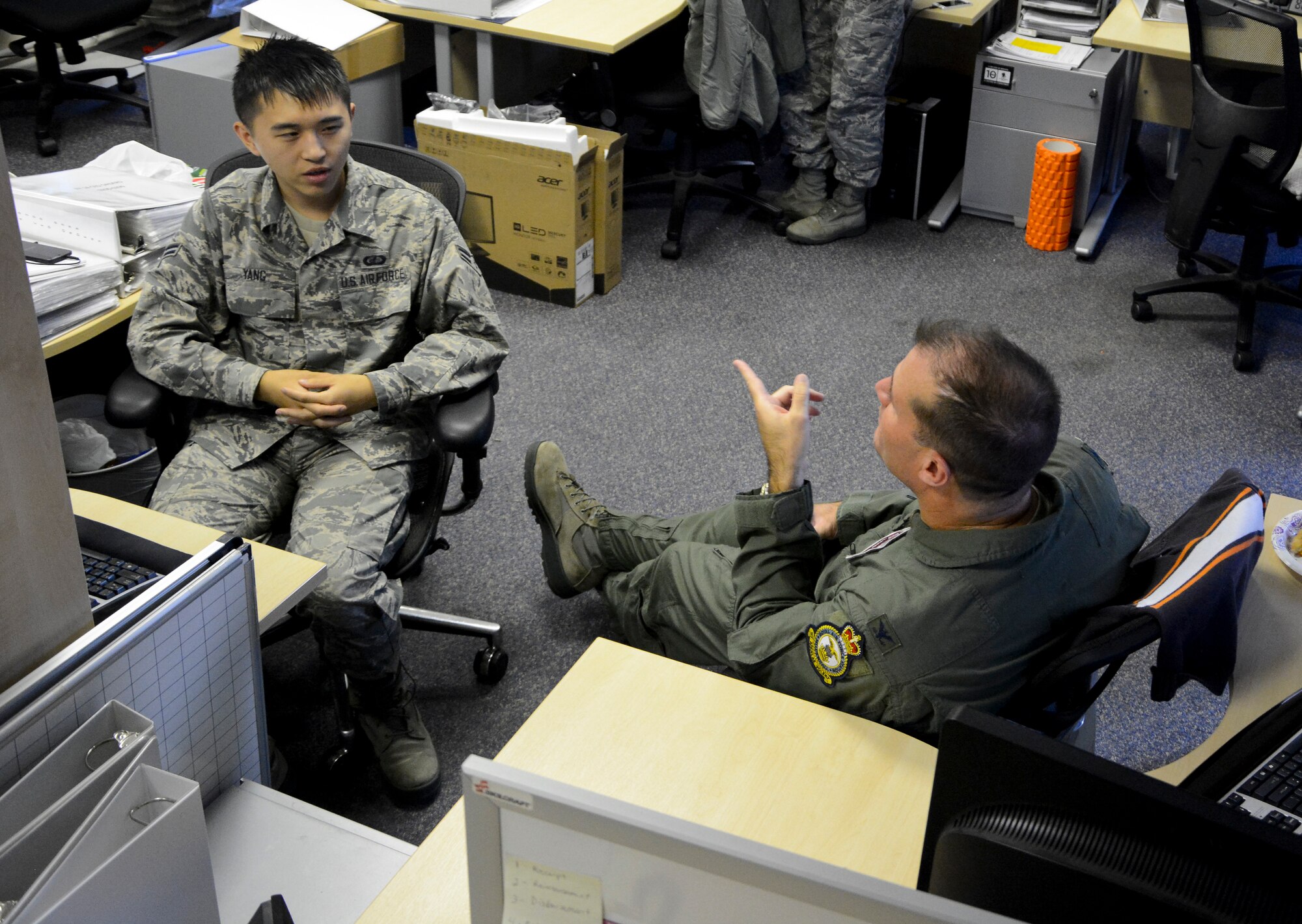 U.S. Air Force Col. Kenneth T. Bibb Jr., right, 100th Air Refueling Wing commander talks with U.S. Air Force Airman 1st Class Leon Shea, 100th Comptroller Squadron budget analyst apprentice from Merced, Calif., Sept. 30, 2014, on RAF Mildenhall, England. Bibb, along with U.S. Air Force Chief Master Sgt. Tracy Jones, 100th Air Refueling Wing command chief, visited with finance Airmen to help boost morale during the end of fiscal year 2014 close out. (U.S. Air Force photo/Staff Sgt. Micaiah Anthony/Released)
