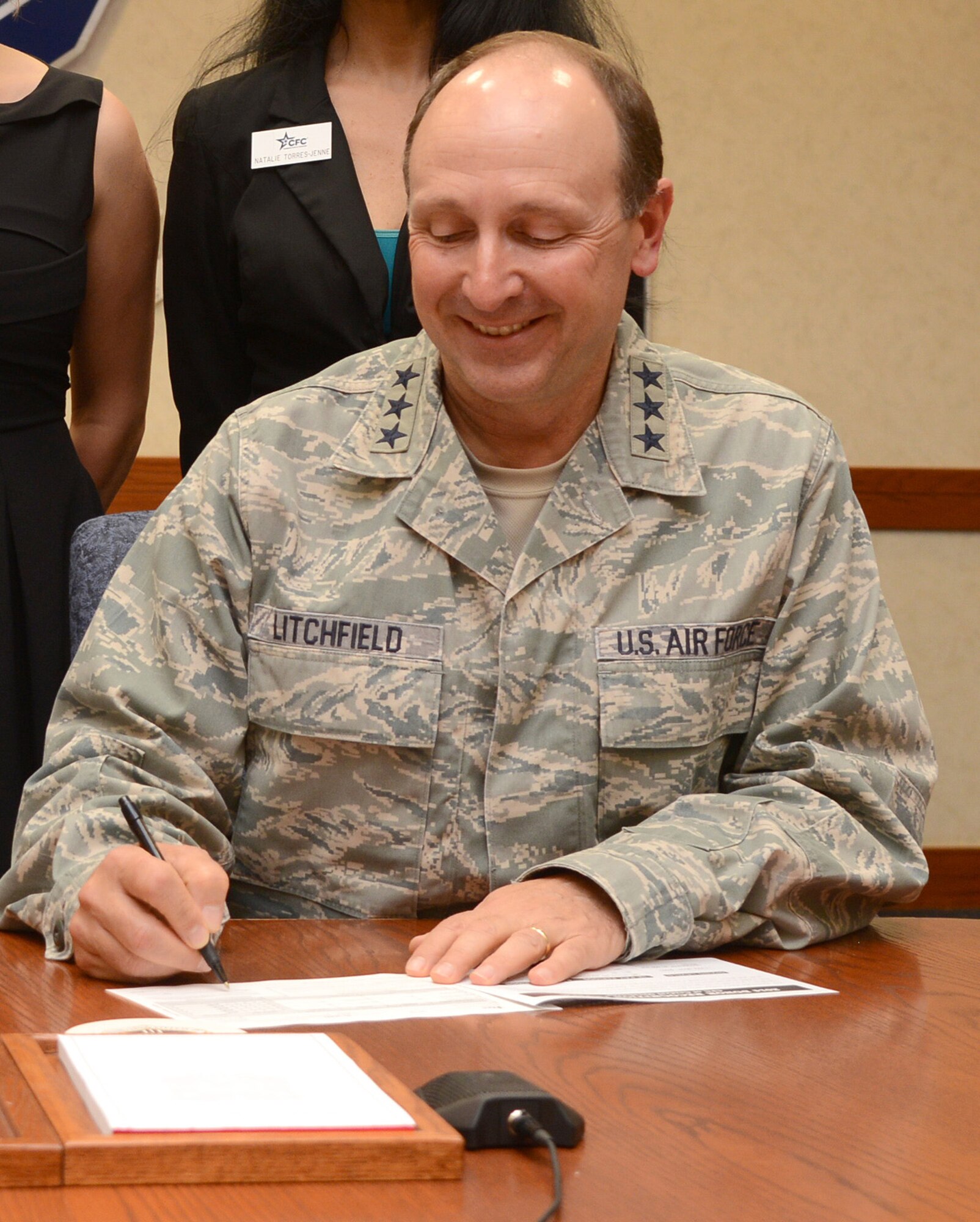 To mark the kick-off of the 2014-15 Combined Federal Campaign, Air Force Sustainment Center Commander Lt. Gen. Bruce Litchfield signs his pledge form Oct. 1.
