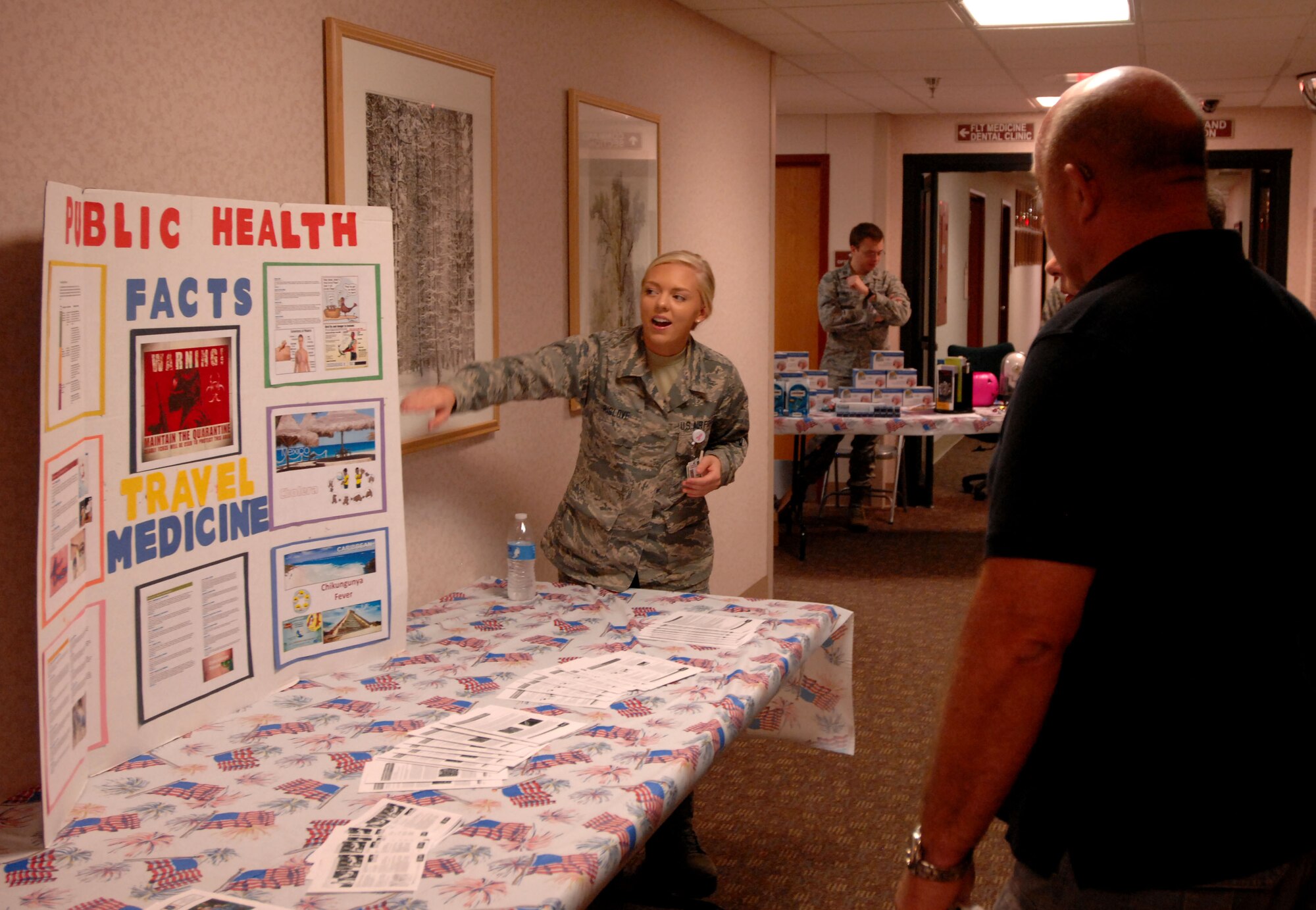 Airman Samantha Rislove, 319th Medical Group public health technician, presents a public health display to military retirees Sept. 27, 2014, on Grand Forks Air Force Base, N.D. Both officer and enlisted Airmen served as facilitators and presenters at the event, which provided free educational materials concerning illness prevention and updates to medical care. (U.S. Air Force photo/Staff Sgt. Susan L. Davis)