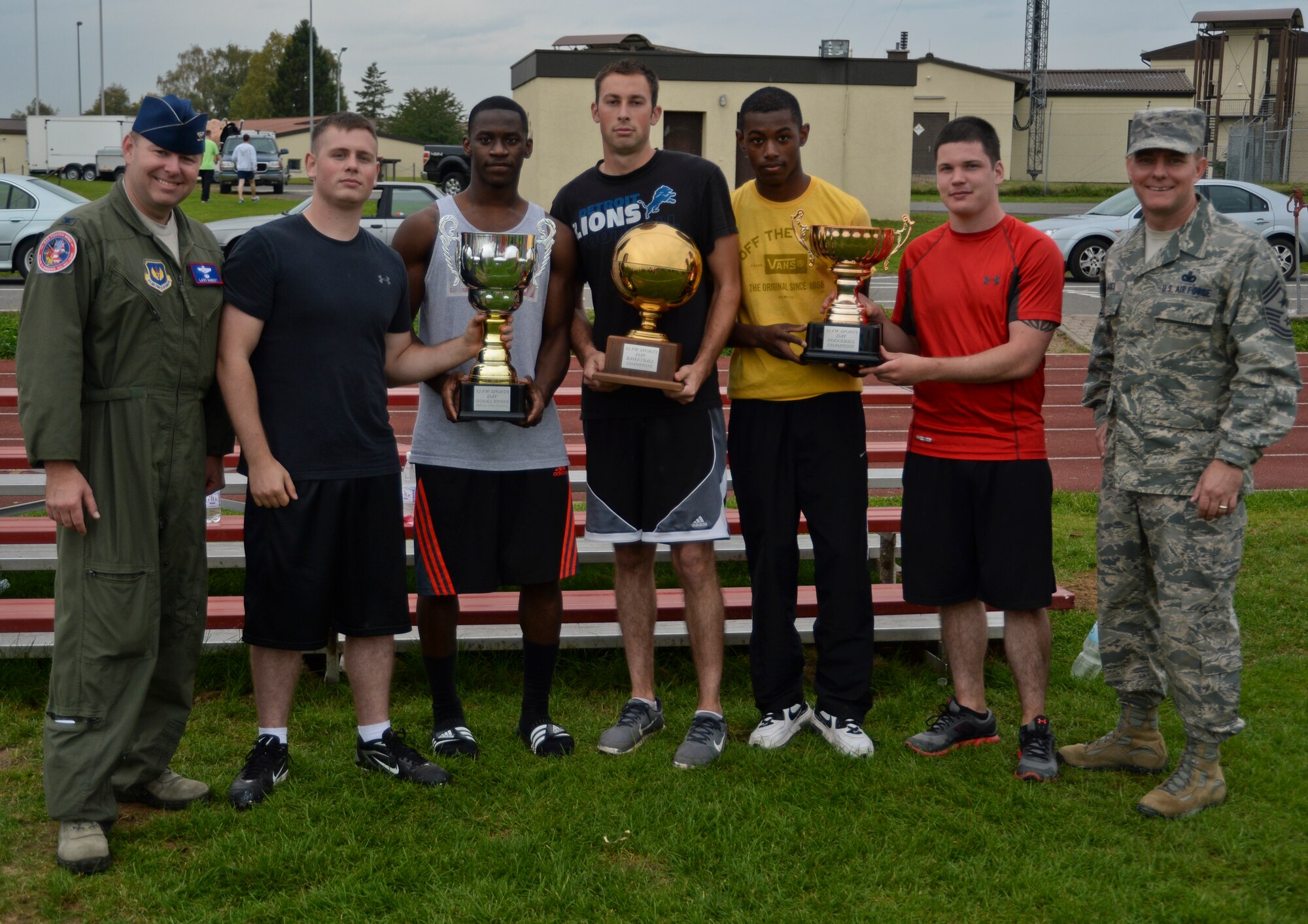 U.S. Air Force Col. Lars Hubert, 52nd Fighter Wing vice commander, left, and U.S. Air Force Chief Master Sgt. Brian Gates, 52nd FW command chief, right, pose with Airmen from the 606th Air Control Squadron and their collection of trophies during the Wing Sports Day competition at the base track at Spangdahlem Air Base, Germany, Sept. 29, 2014. The 606th ACS earned the top trophy for earning the most points during all events held that day. (U.S. Air Force photo by Staff Sgt. Joe W. McFadden/Released)