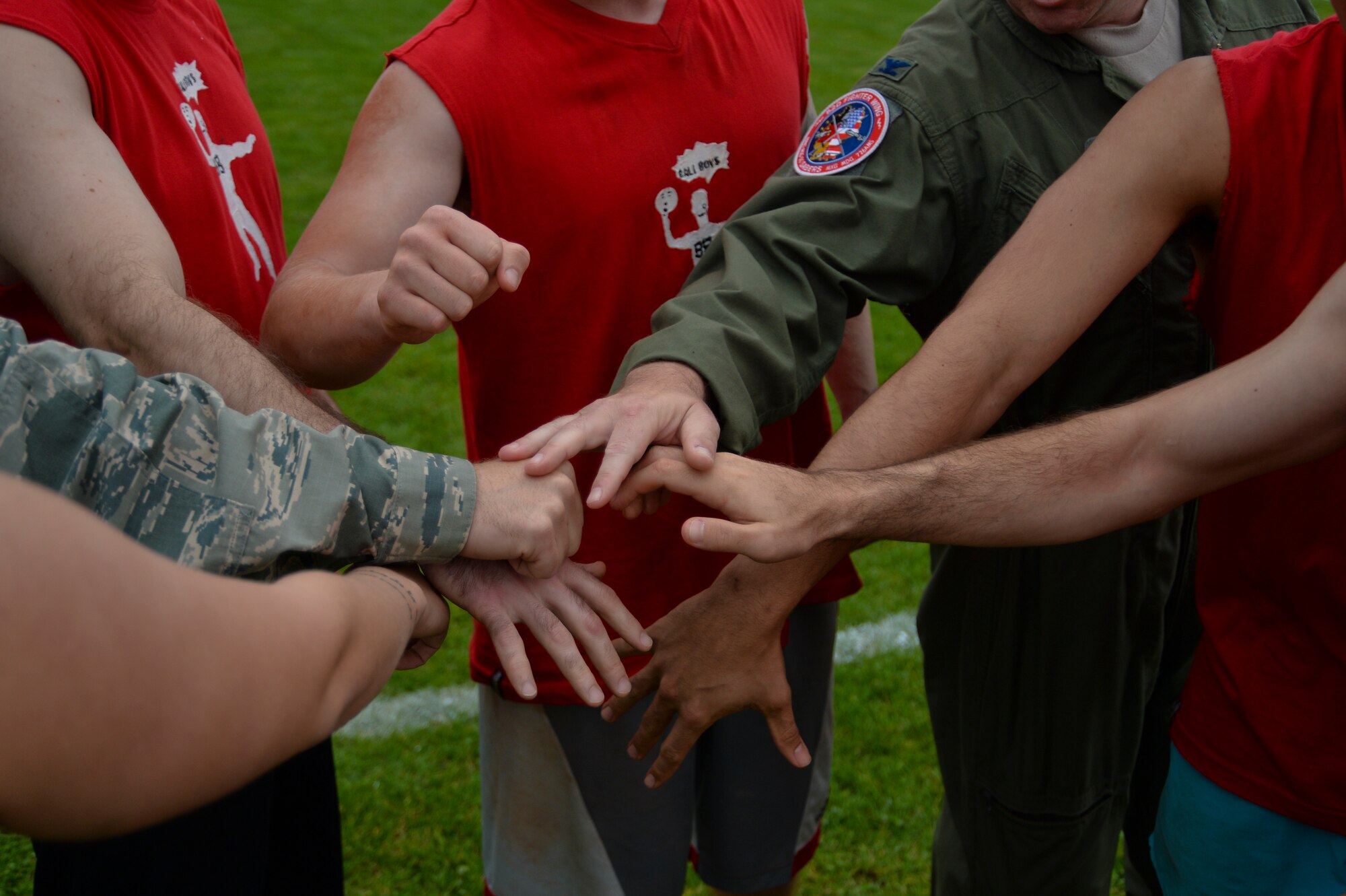 U.S. Air Force Airmen from the 52nd Fighter Wing Staff Agencies place their hands in for a huddle during the Wing Sports Day competition at the base track at Spangdahlem Air Base, Germany, Sept. 29, 2014. The event aimed at boosting esprit de corps among the 52nd FW and offered physical and social competition as part of U.S. Air Forces in Europe’s RUFit? Campaign. (U.S. Air Force photo by Staff Sgt. Joe W. McFadden/Released)