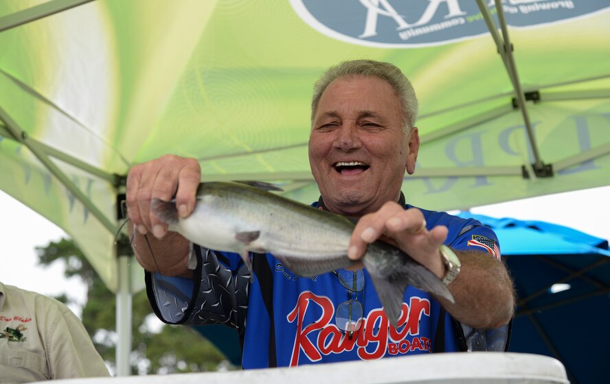David Leonard, Lowndes County Bassmasters weight master, weighs a fish during the Youth Fishing Rodeo Sept. 27, 2014, at Grassy Pond in Lake Park, Ga. Children competed in one of three age groups for the most fish caught and biggest fish. (U.S. Air Force photo by Senior Airman Sandra Marrero/Released)
