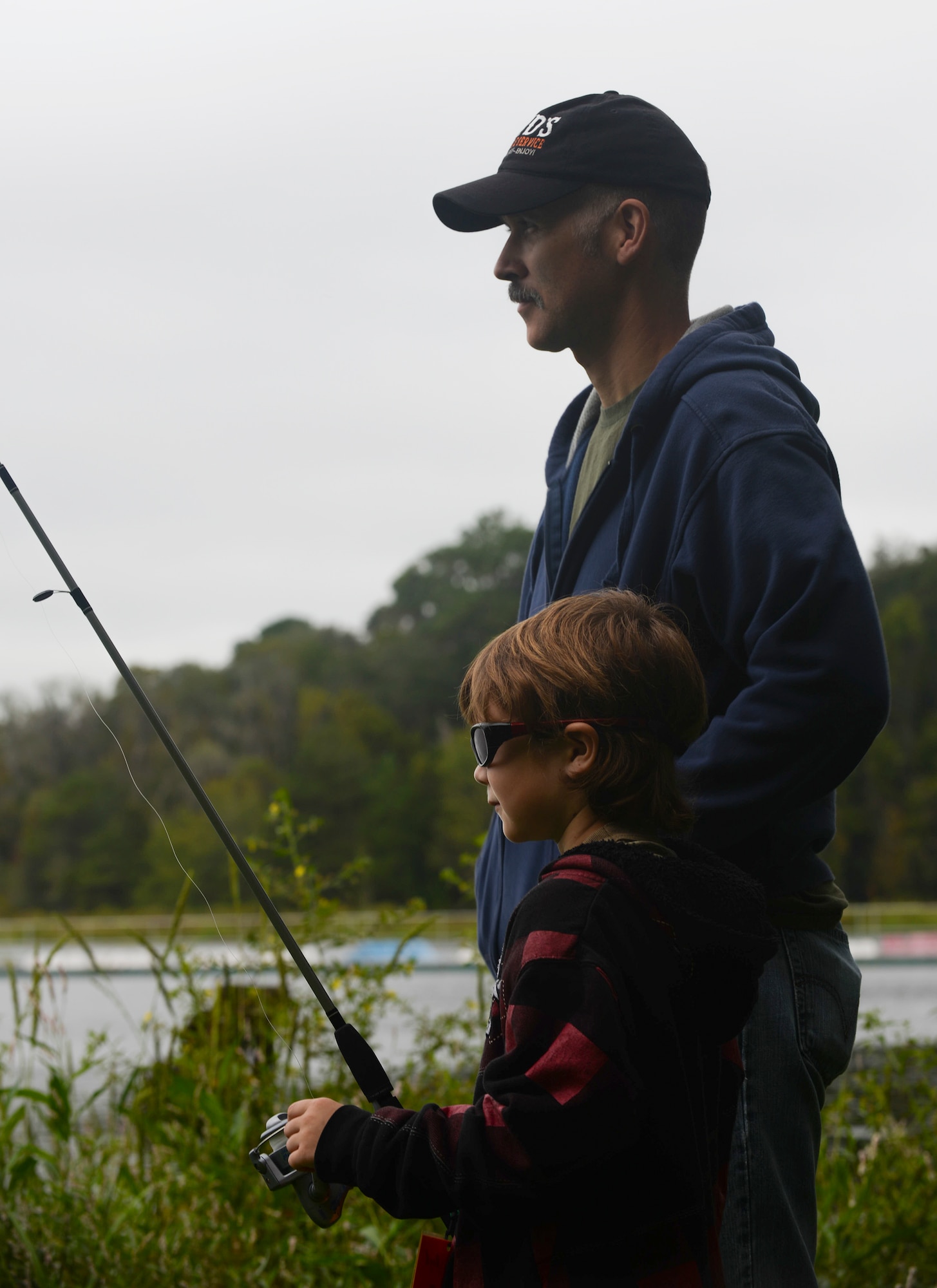 Seamus Boyd and father Jesse Boyd fish during the Youth Fishing Rodeo Sept. 27, 2014, at Grassy Pond in Lake Park, Ga. Moody Air Force Base collaborated with the Lowndes County Parks and Recreation Authority to host this event. (U.S. Air Force photo by Senior Airman Sandra Marrero/Released)
