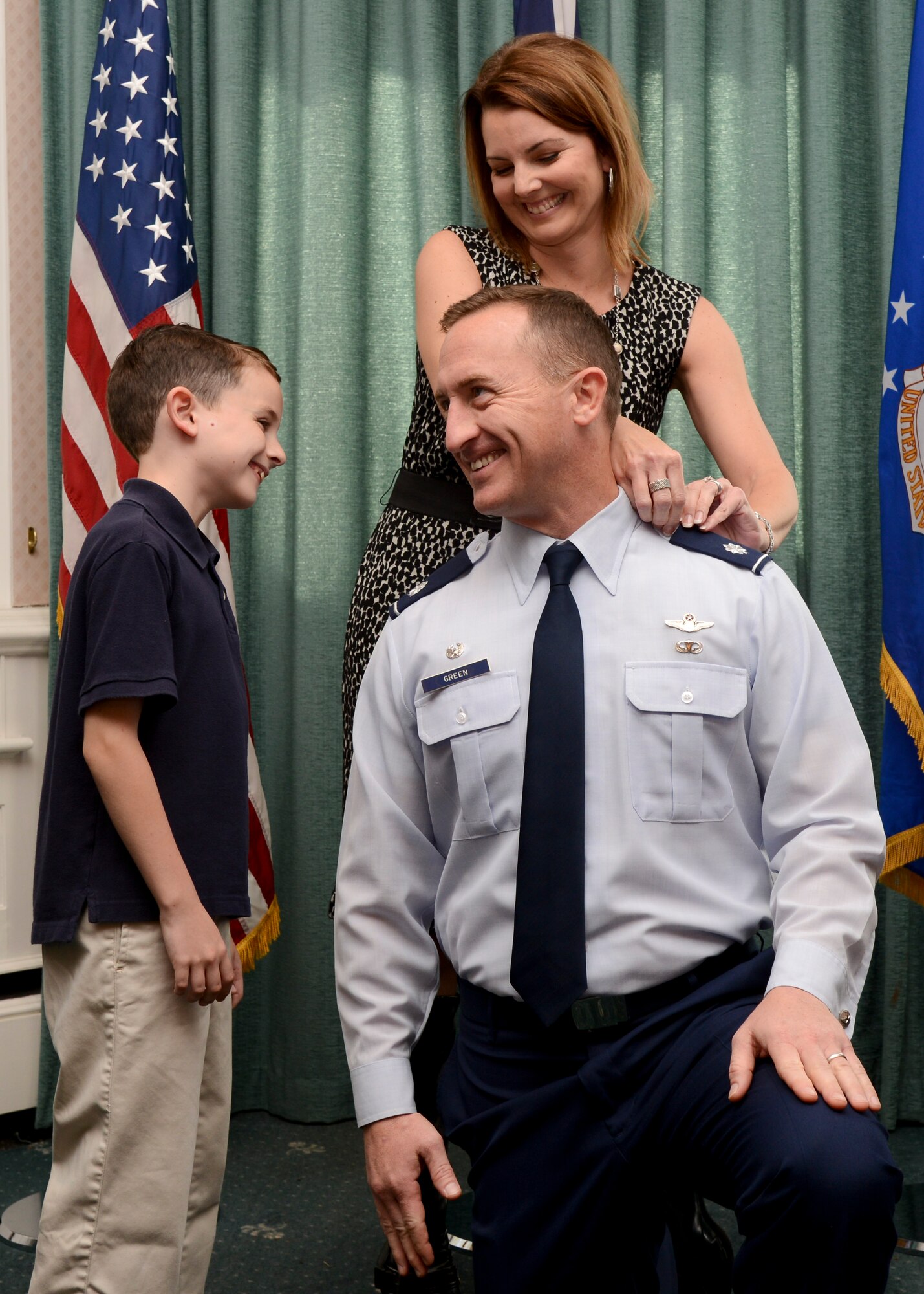Then U.S. Air Force Lt. Col. Nathan Green, 352nd Special Operations Group commander, kneels while his wife, Traci, and his youngest son, Drew, remove the rank insignia during his promotion ceremony Sept. 30, 2014, on RAF Mildenhall, England. Green promoted to colonel and leads the independent 352nd SOG along with five squadrons, 1,100 personnel and 14 aircraft. (U.S. Air Force photo/Senior Airman Victoria H. Taylor/Released)