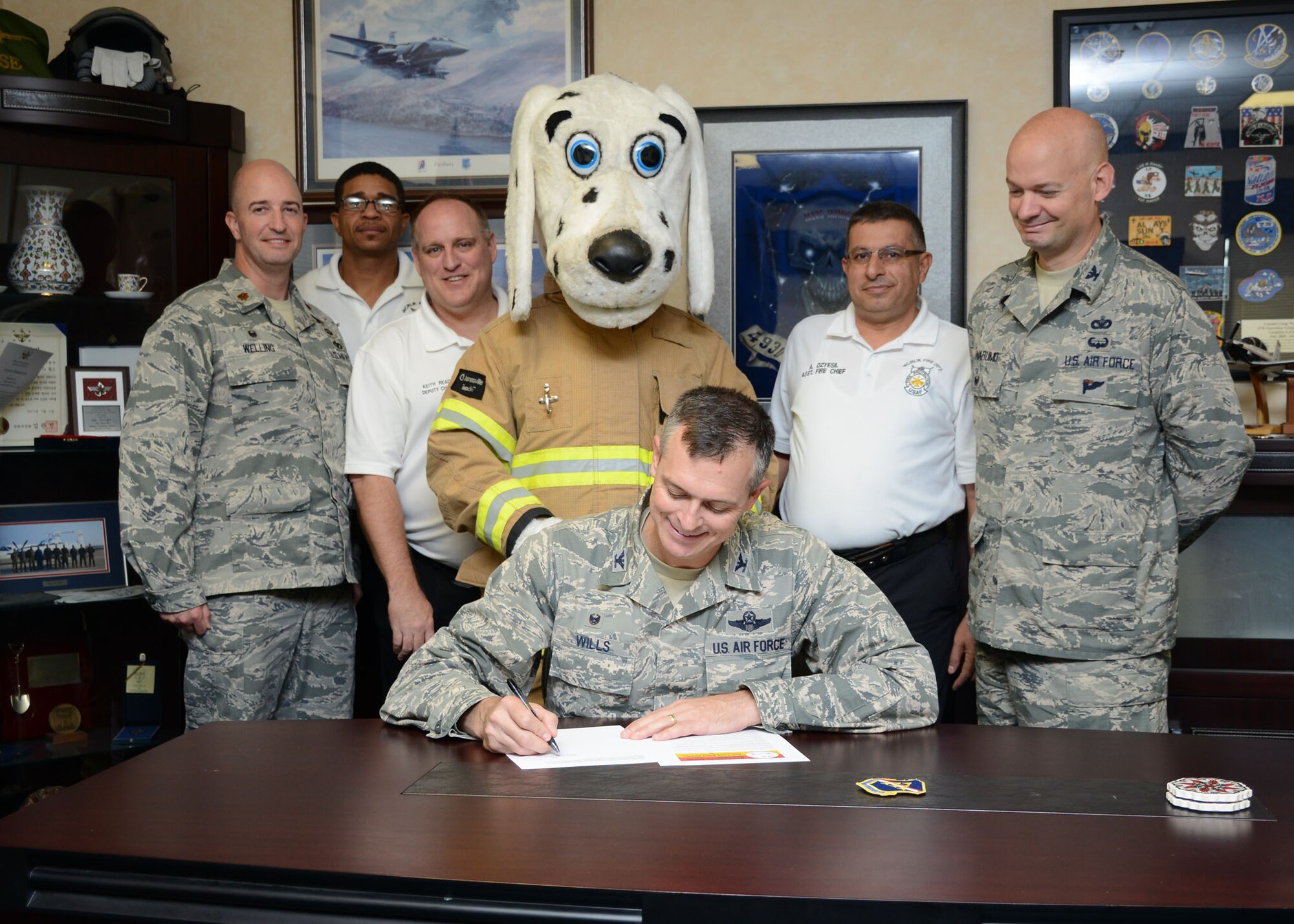 Col. Craig Wills, 39th Air Base Wing commander, and Sparky the Fire Dog, sign a proclamation for Fire Prevention Week, Oct. 2, 2014, Incirlik Air Base, Turkey. Fire Prevention Week is observed throughout the U.S. on Oct. 5-11. The Incirlik AB Fire Department will host various educational events on fire prevention and safety techniques throughout the week.  (U.S. Air Force photo by Staff Sgt. Veronica Pierce/Released) 