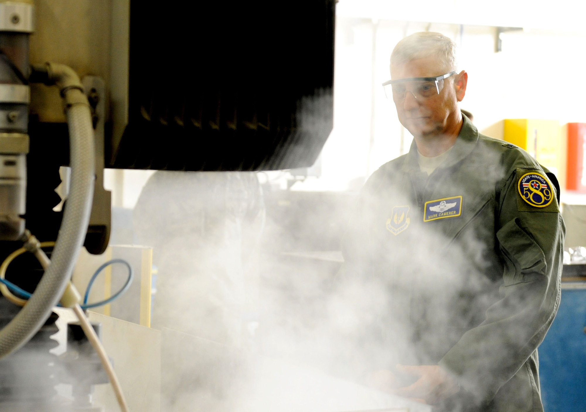 U.S. Air Force Brig. Gen. Mark Camerer, U.S. Air Forces in Europe and U.S. Air Forces Africa director of plans, programs and analyses, watches a metals technology demonstration during a tour of the 100th Maintenance Group Sept. 30, 2014, on RAF Mildenhall, England. During Camerer’s first visit to RAF Mildenhall since assuming his current position, he toured several facilities and met a multitude of Airmen to better understand the base’s requirements and mission capabilities. (U.S. Air Force photo/Senior Airman Kate Maurer/Released) 