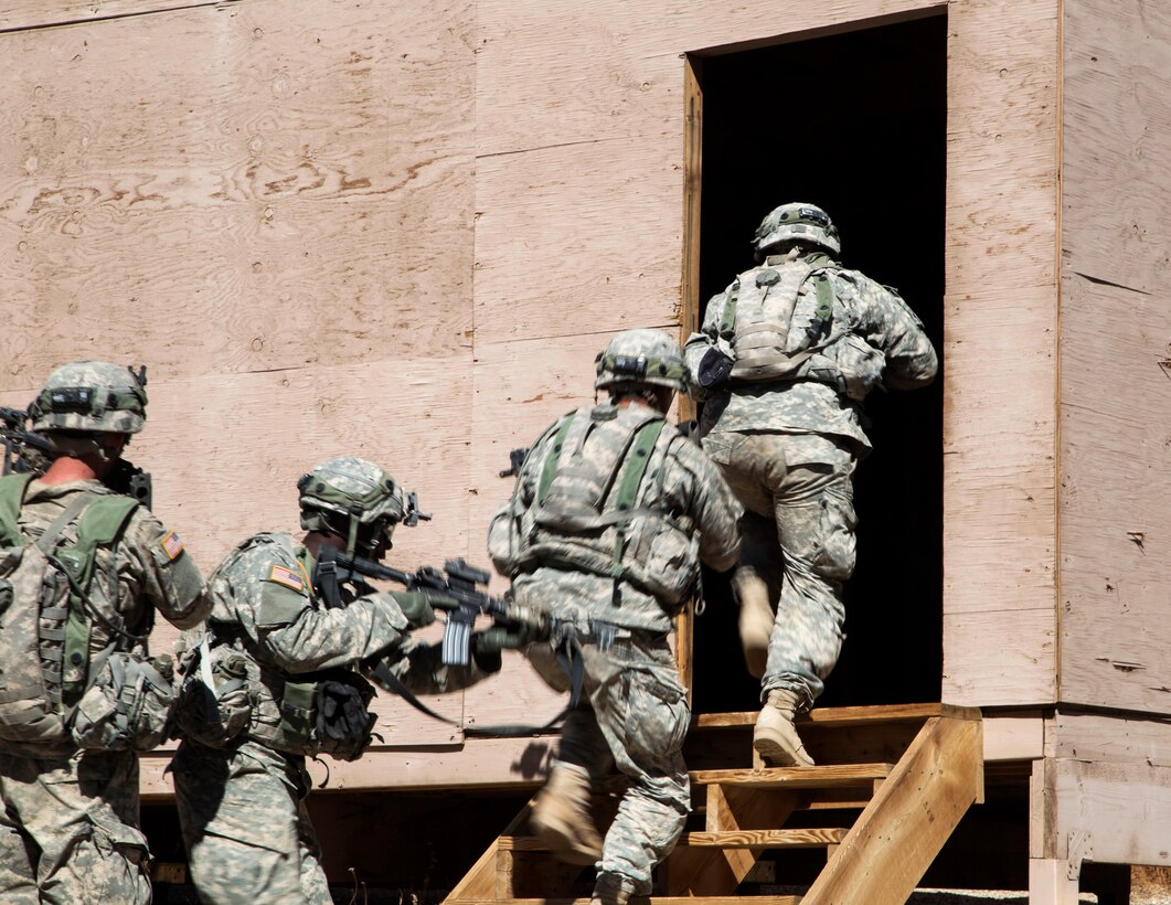 Soldiers enter a building after breaching an enemy compound during rotation 14-10 at the National Training Center on Fort Irwin, Calif., Sept. 18, 2014.