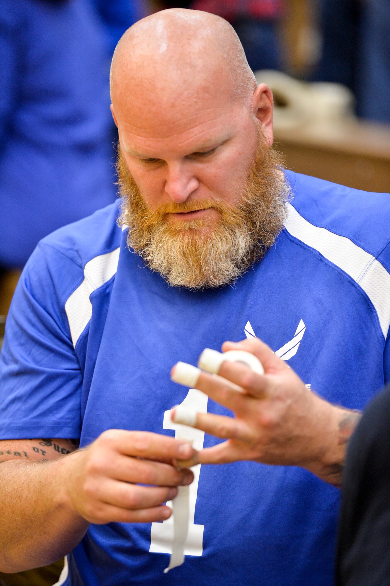 Retired Air Force Tech. Sgt. Ketih Sekora tapes up his fingertips prior to the start of the 2014 Warrior Games sitting volleyball bronze medal match between the Air Force and the Army Oct. 1, 2014, at the U.S. Olympic Training Center in Colorado Springs, Colo. The Army beat the Air Force in two sets, 25-20, 25-19. (U.S. Air Force photo/Staff Sgt. Devon Suits)