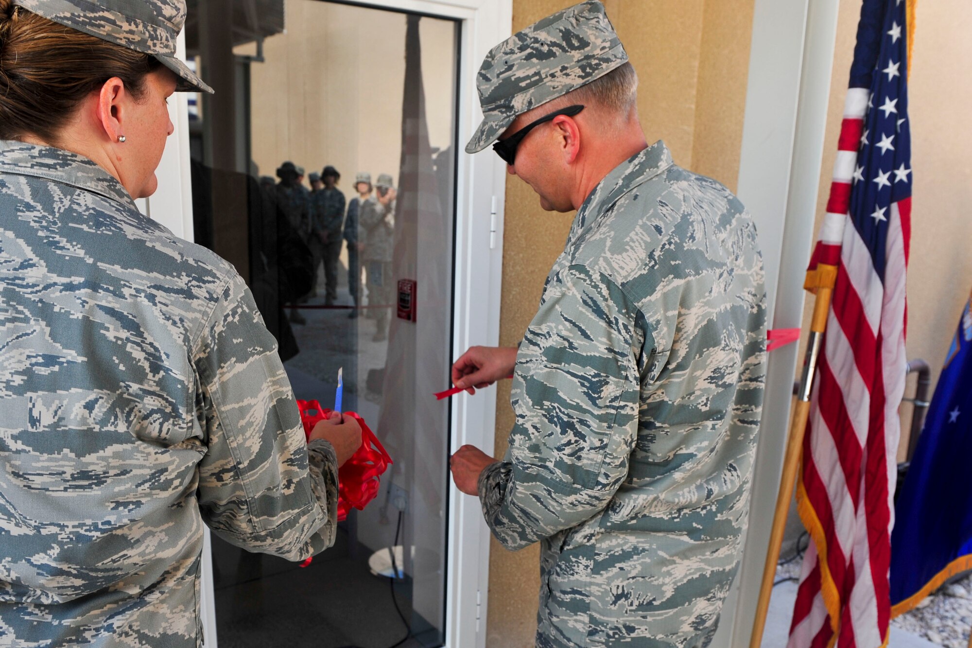 U.S. Air Force Brig. Gen. Darren Hartford, right, 379th Air Expeditionary Wing commander, and Col. Andrea Vinyard, 379th Expeditionary Medical Group commander, cut the ribbon on a new En-route Patient Staging Facility at Al Udeid Air Base, Qatar, Sept. 30, 2014. The new facility will increase capabilities by more than 160 percent, going from 13 beds to 21. (U.S. Air Force photo by Senior Airman Colin Cates)  