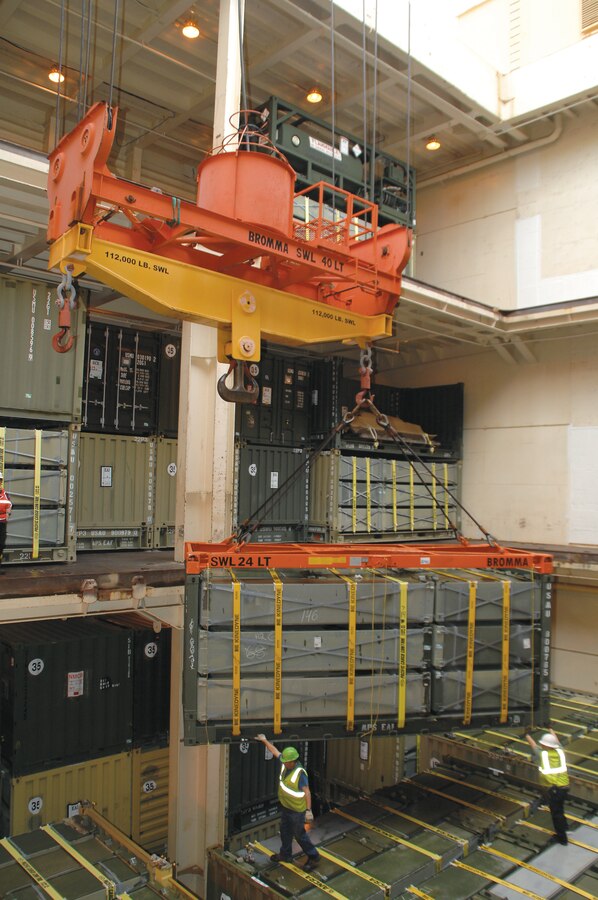 Stevedores move a container into place during a backload operation on a maritime prepositioning vessel, Sept. 23.