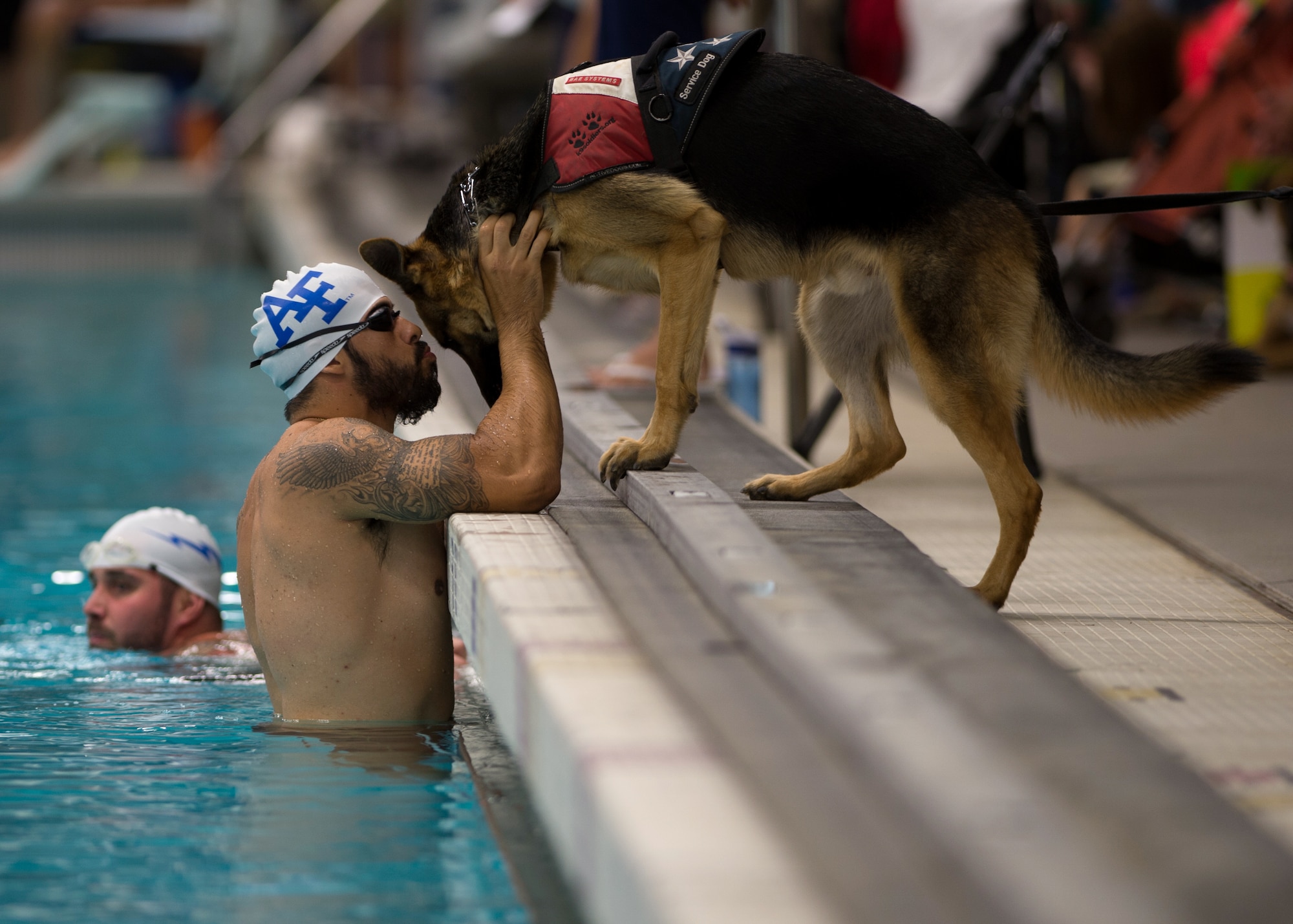 Air Force athlete August O'Niell kisses his service dog, Kai, during warmups for the swimming portion of the 2014 Warrior Games Sept. 30, 2014, at the U.S. Olympic Training Center in Colorado Springs, Colo. The Warrior Games consist of athletes from the Defense Department, who compete in Paralympic-style events for their respective military branch. (U.S. Air Force photo/Senior Airman Justyn M. Freeman)