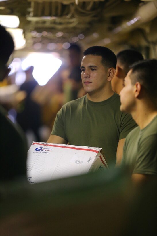 U.S. Marine Corps Sgt. Adrian A. Garcia, a radio operator with the 1st Air Naval Gunfire Liaison Company, 11th Marine Expeditionary Unit (MEU), and a native of Santa Ana, California, holds a package during a replenishment-at-sea aboard the USS San Diego (LPD 22), Sept. 29. Marines from the 11th MEU are deployed with the Makin Island Amphibious Ready Group as a flexible, adaptable and persistent force in the U.S. 5th Fleet area of responsibility. (U.S. Marine Corps photo by Cpl. Jonathan R. Waldman/Released)