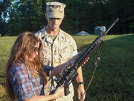 Marines with 8th Engineering Support Battalion, 2nd Marine Logistics Group teamed up with their spouses to participate in a Jane Wayne day aboard Camp Lejeune, N.C., Sept. 30, 2014. 1st Sgt. Eric Bauer, the Bravo Company first sergeant with the unit and native of Swansboro, N.C., explains the functions and safety features of the M16 A4 service rifle to his wife Shelly Bauer. Jane Wayne day is designed to show spouses a few of the jobs their Marines perform and to strengthen the bond between unit and family. (U.S. Marine Corps photo by Cpl. Michael Dye / Released)