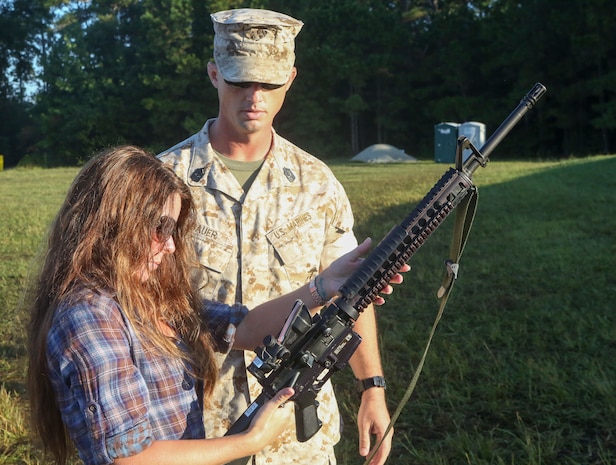 Marines with 8th Engineering Support Battalion, 2nd Marine Logistics Group teamed up with their spouses to participate in a Jane Wayne day aboard Camp Lejeune, N.C., Sept. 30, 2014. 1st Sgt. Eric Bauer, the Bravo Company first sergeant with the unit and native of Swansboro, N.C., explains the functions and safety features of the M16 A4 service rifle to his wife Shelly Bauer. Jane Wayne day is designed to show spouses a few of the jobs their Marines perform and to strengthen the bond between unit and family. (U.S. Marine Corps photo by Cpl. Michael Dye / Released)