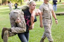 Catherine Lewis firemans carries her husband, Lance Cpl. Andrew Lewis, a bulk fuel specialist with 8th Engineering Support Battalion, and Kalamazoo, Mich., native, while conducting the movement under fire portion of the Combat Fitness Test during the unit’s Jane Wayne day aboard Marine Corps Base Camp Lejeune, N.C., Sept. 30, 2014. Catherine performed the MUF with a time of 3:55, which is a passing score of 88 out of 100 points. Jane Wayne day is designed to show spouses a few of the jobs their Marines perform and to strengthen the bond between unit and family. (U.S. Marine Corps photo by Cpl. Michael Dye / Released)