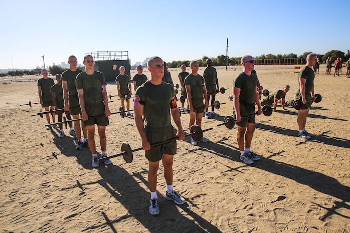 Recruits of Alpha Company, 1st Recruit Training Battalion, prepare to begin bicep curls during the circuit course event at Marine Corps Recruit Depot San Diego, Sept. 25. The Circuit Course is comprised of more than 20 exercise stations, each with its own purpose. These exercises included monkey bars, jump ropes and weight lifting. 