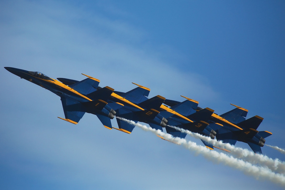 JOINT BASE PEARL HARBOR-HICKAM - U.S. Navy Flight Demonstration Squadron, the Blue Angels, perform a variety of tricks over Joint Base Pearl Harbor-Hickam during the Wings Over the Pacific air show on Sept. 27 and 28. The U.S. Air Force F-22 Raptor demonstration team perform a left echelon roll. (U.S. Marine Corps photo by Pfc. Harley Thomas)