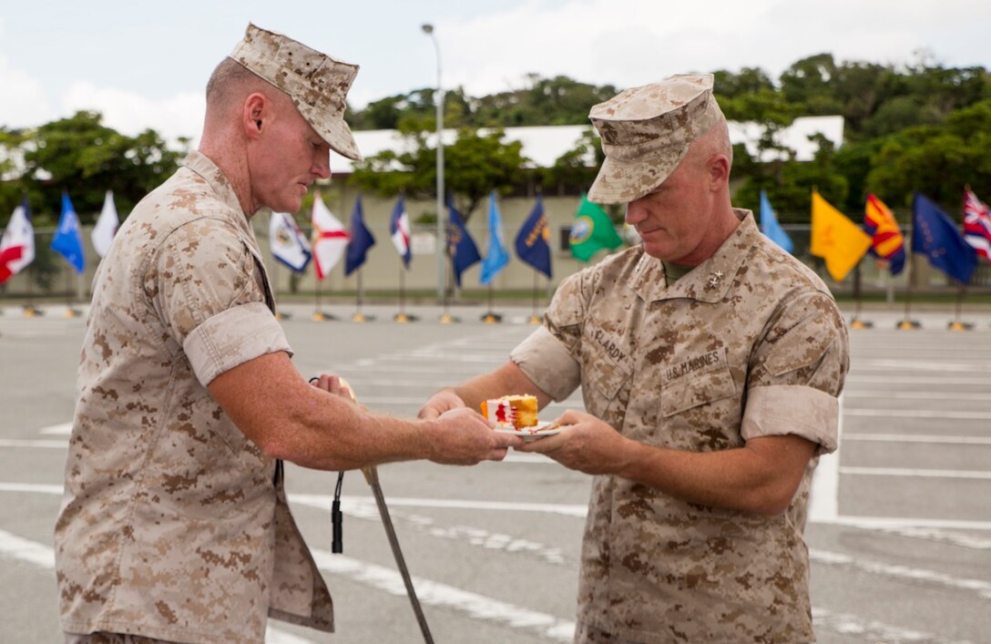 Sgt. Maj. Paul G. McKenna, left, passes a piece of cake to Maj. Gen. H. Stacy Clardy III Sept. 16 during the 3rd Marine Division’s 72nd anniversary ceremony on Camp Hansen. The first piece of cake was presented to the guest of honor. After the guest of honor ate the first piece of cake, the youngest and oldest Marines in the unit received a piece to symbolize the passing of tradition from older to younger generations. Clardy is from Pawleys Island, South Carolina, and is the commanding general of the 3rd Marine Division, III Marine Expeditionary Force. McKenna is the sergeant major of the division. (U.S. Marine Corps photo by Lance Cpl. Rebecca Elmy/Released)