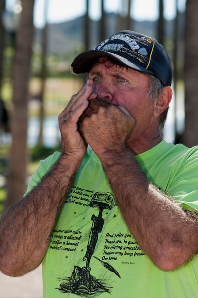 Phillip "little dog" Rodgers, U.S. Army Vietnam veteran, plays taps on the harmonica near "The Moving Wall," a Vietnam veterans memorial wall, in Goodyear, Arizona, Oct. 03, 2014. Rodgers travels around the country with the wall to play taps and pay respect to the veterans and those killed or missing in action. (U.S. Air Force photo by Staff Sgt. Staci Miller) 