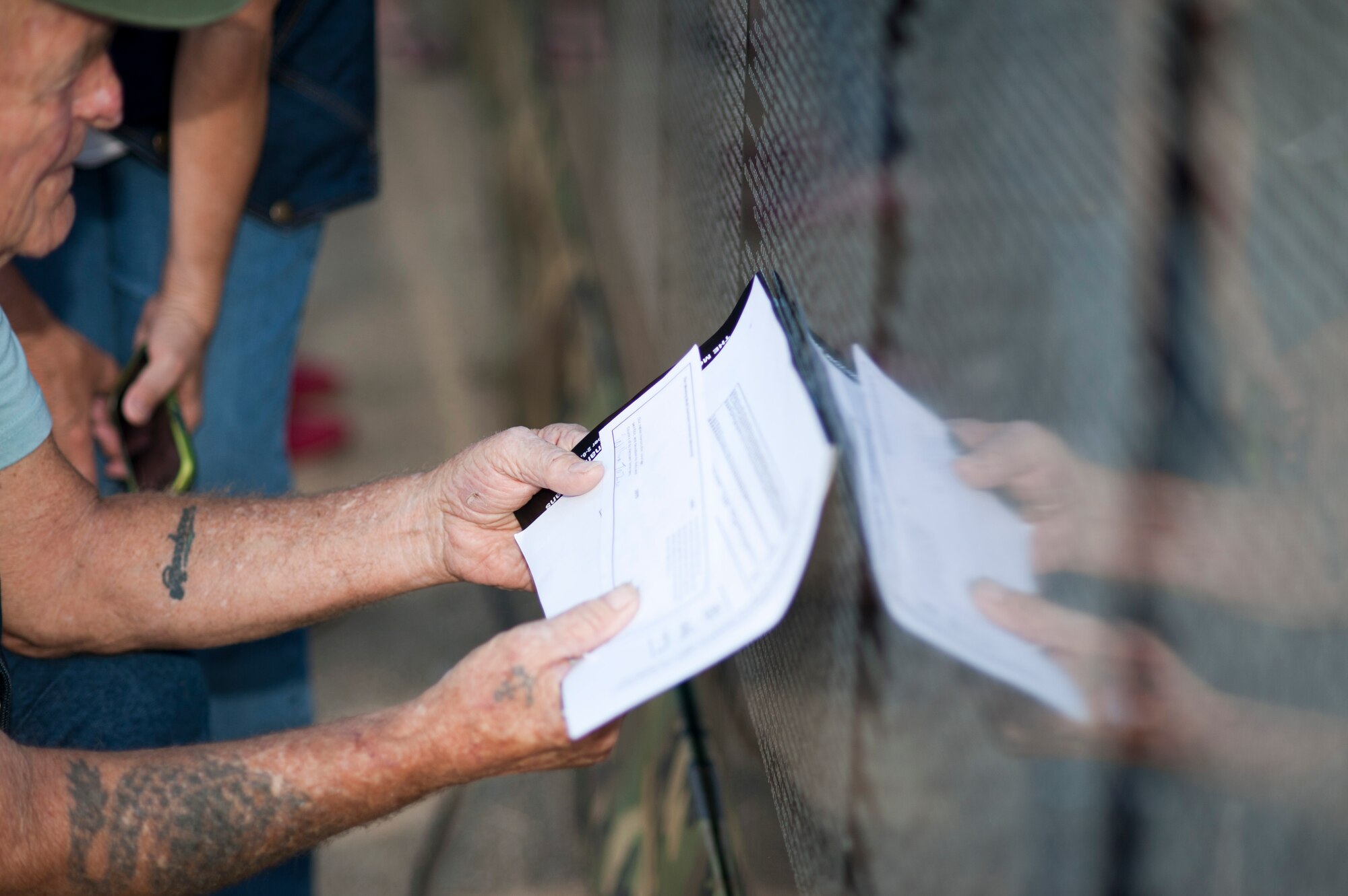 Ed Doughty, U.S. Navy Vietnam veteran, searches for names on "The Moving Wall," a Vietnam veterans memorial wall, in Goodyear, Arizona, Oct. 03, 2014. Inscribed on the black granite walls are the names of more than 58,249 men and women who gave their lives or remain missing. (U.S. Air Force photo by Staff Sgt. Staci Miller) 