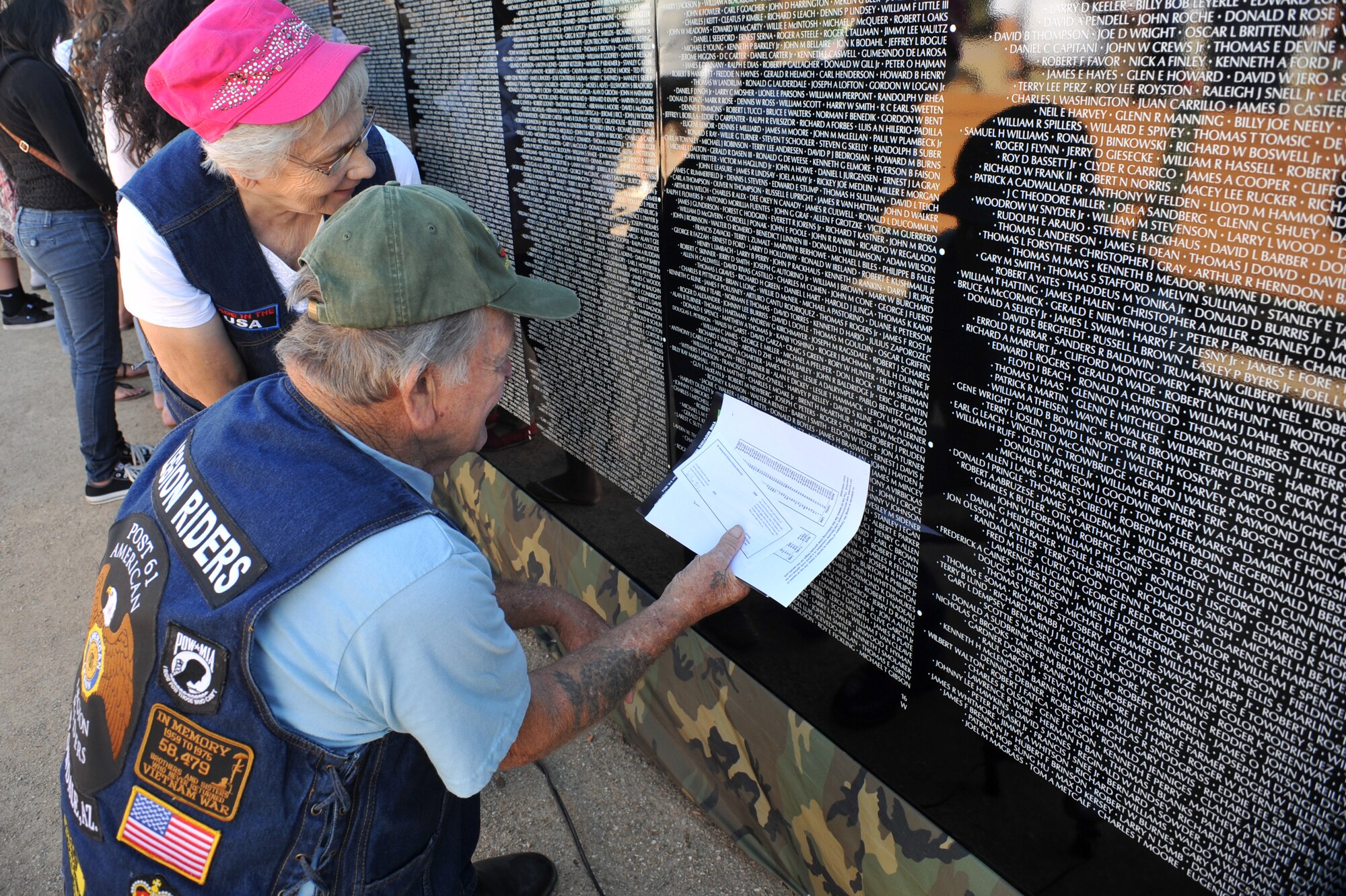 Ed Doughty, U.S. Navy Vietnam Veteran, and his wife Irene, search for names on The Moving Wall, a Vietnam Veterans Memorial on display in Goodyear, Arizona, Oct. 3, 2014. Inscribed on the black granite walls, are the names of the more than 58,000 Vietnam Veterans who gave their lives or remain missing in action. (U.S. Air Force Photo by Senior Airman Jenna Sarvinski) 