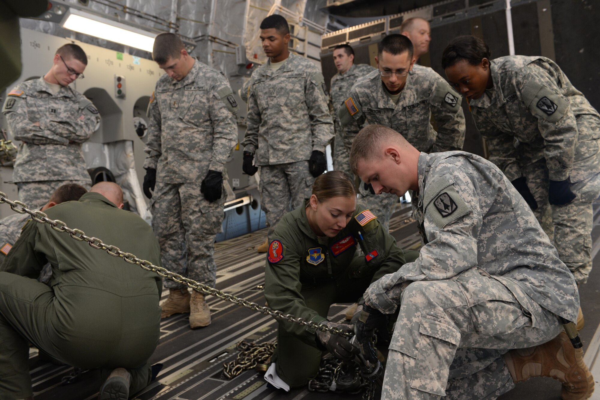 ALTUS AIR FORCE BASE, Okla. – U.S. Air Force Staff Sgt. Laura Bourdlais, 58th Airlift Squadron instructor loadmaster, explains the process of restraining a vehicle with a group of U.S Army Soldiers from 4th Battalion, 3rd Air Defense Artillery Regiment, 31st Air Defense Artillery Brigade, Fort Sill, Okla., Oct. 2, 2014. The Soldiers learned how to secure their vehicles, a skill needed if the U.S. Air Force is not available to transport the battalion’s equipment during a rapid deployment. (U.S. Air Force photo by Airman 1st Class Megan E. Acs/Released)