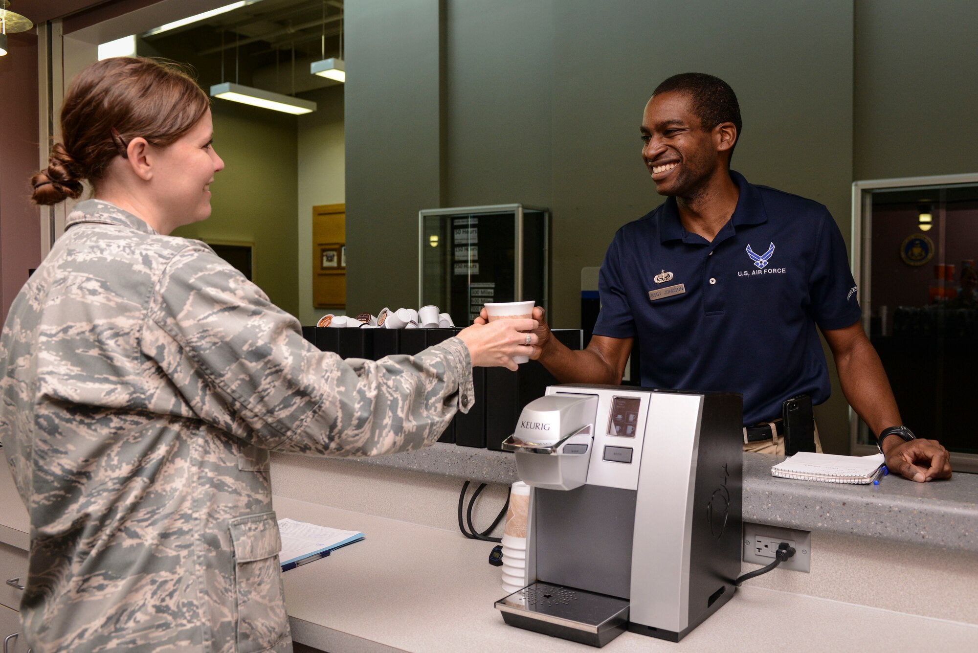 Ch. (Capt.) Jayme Kendall, 91st Missile Wing Chaplain, hands a cup of coffee to
Staff Sgt. Kenneth Johnson, NCO in charge of the fitness assessment cell, at
the chapel's free coffee and slushy counter in the McAdoo Sports and Fitness
Center on Minot Air Force Base, N.D., Aug. 5, 2014. The counter has offered
free beverages since the summer of 2013 and is open from 7:30 a.m. to 9 a.m.
Tuesday, Wednesday and Thursday. (U.S. Air Force photo/ Senior Airman
Stephanie Morris)