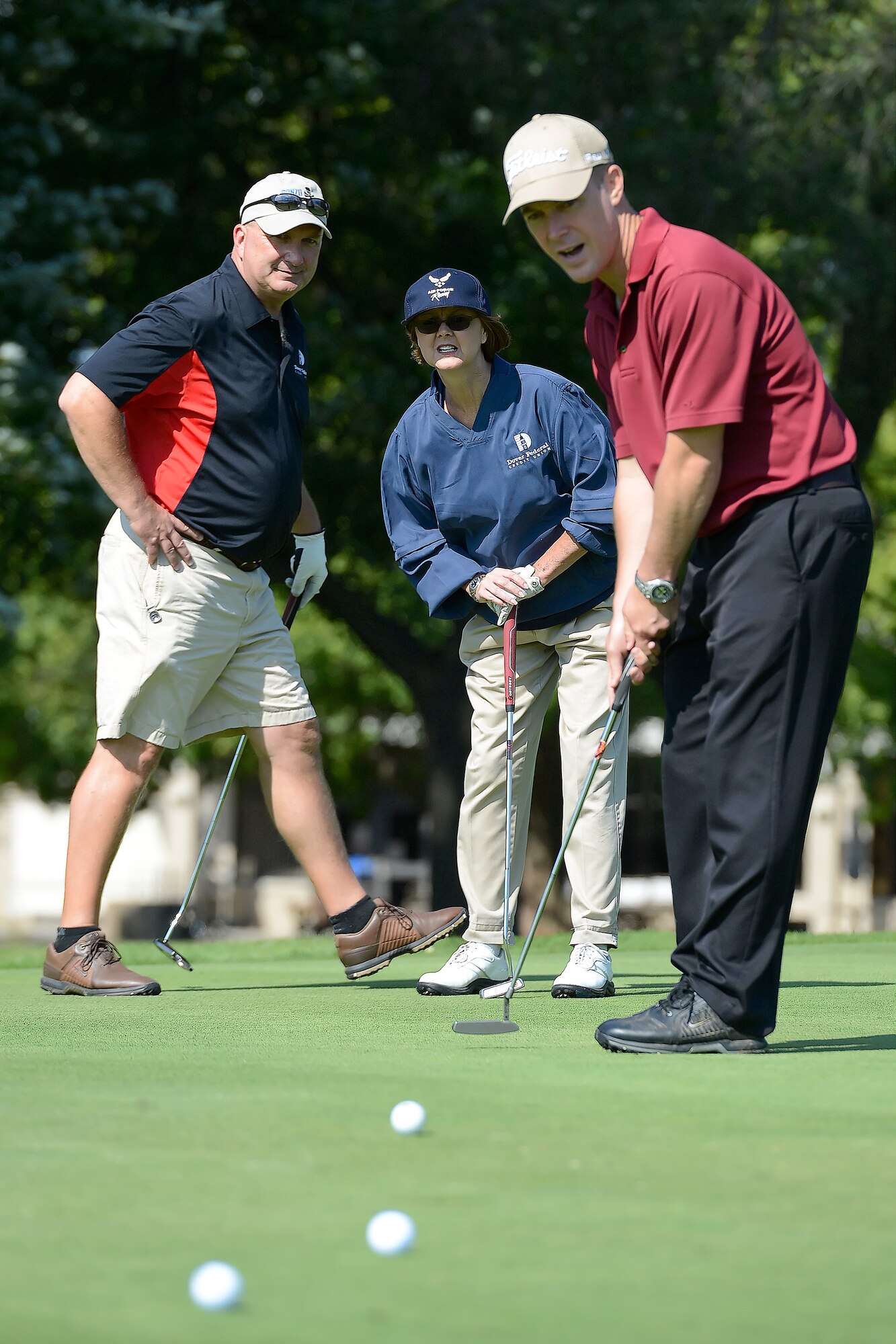 Dave Clendaniel, left, former honorary commander, and Bettie Campbell, 436th Dental Squadron honorary commander, watch Col. Kevin J. Gordon's, 436th Airlift Wing vice commander, golf ball with excitement as it rolls toward the 9th hole at Eagle's Landing Golf Course, Dover Air Force Base, Del., Oct. 3, 2014. Key military leaders from Dover AFB were paired with local civic and business leaders for the Bluesuiters Golf Tournament as part of Dover's robust community outreach program. Dover AFB enjoys outstanding support from surrounding communities and events like this cement those ties. (U.S. Air Force photo/Greg L. Davis)