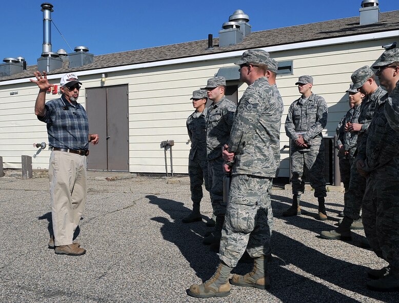 John Gorman, outdoor recreation manager for Grand Forks Air Force Base, N.D., leads a group of Airmen touring the Oscar-Zero Missile Alert Facility outdoors while sharing what his responsibilities were as the facility manager of the MAF many years ago in Cooperstown, N.D., Sept 26, 2014. Gorman was one of four briefers from Grand Forks AFB that accompanied the tour to the MAF. (U.S. Air Force photo/Airman 1st Class Bonnie Grantham)
