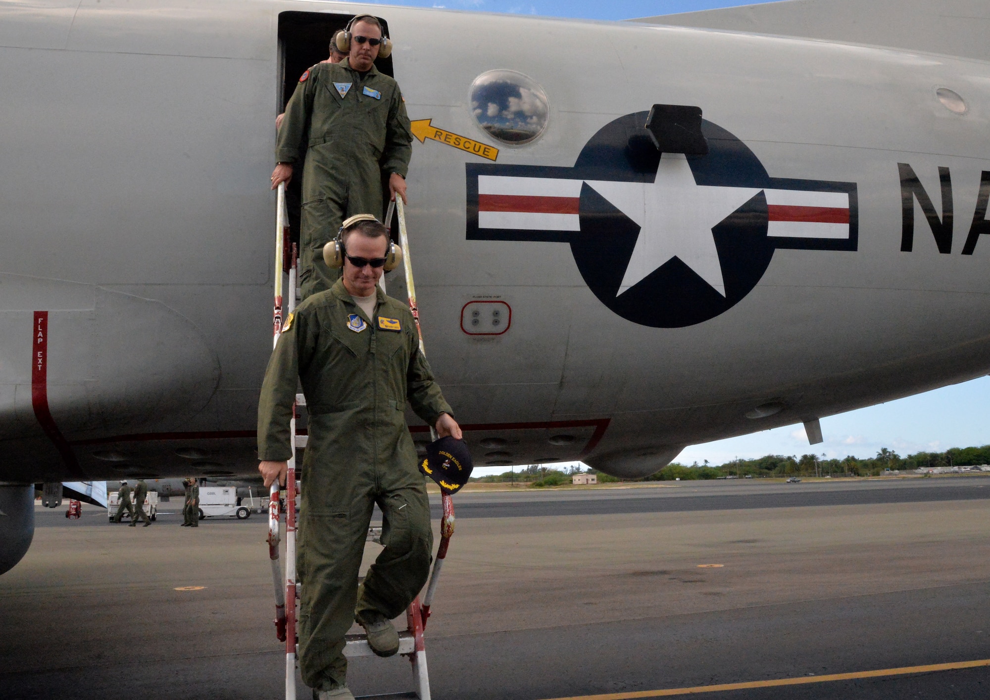 Col. Randy Huiss, 15th Wing commander, front, and Navy Capt. Lance Scott, Patrol and Reconnaissance Wing Two commander, exit a P-3 Orion maritime patrol aircraft after a brief tour at Joint Base Pearl Harbor-Hickam, Hawaii, Oct. 2, 2014. Navy and Marine Corps aircraft have temporarily relocated to JBPHH due to airfield construction at Marine Corps Air Station Kaneohe Bay. (U.S. Air Force photo by Staff Sgt. Alexander Martinez)