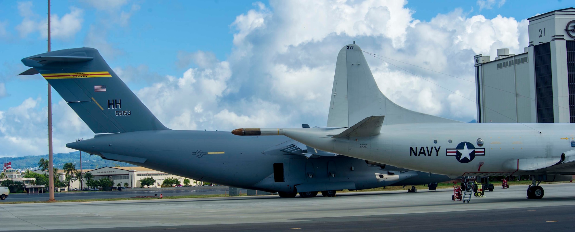 A P-3 Orion maritime patrol aircraft sits next to a C-17 Globemaster III on the Joint Base Pearl Harbor-Hickam, Hawaii, flightline Oct. 2, 2014. Navy and Marine Corps aircraft have temporarily relocated to JBPHH due to airfield construction at Marine Corps Air Station Kaneohe Bay. The aircraft commenced flying operations here Oct. 1. (U.S. Air Force photo by Tech. Sgt. Terri Paden)