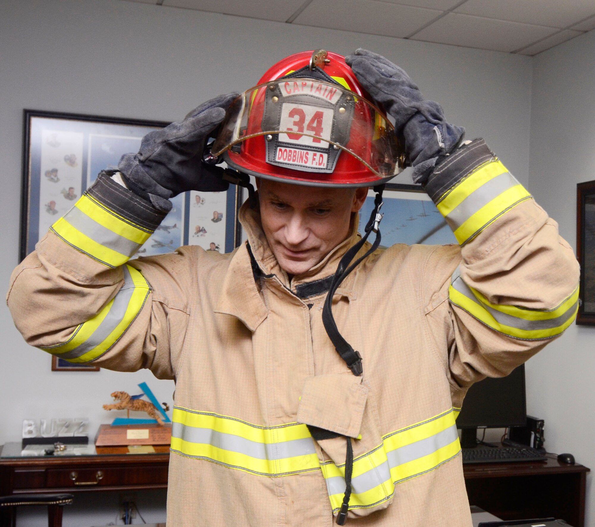 Col. Brett Clark, 94th Airlift Wing commander, puts on a fire suit for Dobbins Fire Prevention Week 2014, Oct. 3, 2014, at Dobbins Air Reserve Base, Ga. Fire Prevetion Week lasts from Oct. 6 through 10. (U.S. Air Force photo by Don Peek/Released)