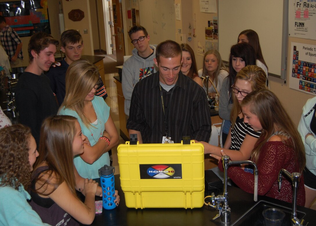 Mr. Bart Blumberg, science teacher at Rock Canyon High School and Traditional Guardsmen with the Colorado Air National Guard, demonstrates how the equipment used by the Emergency Management team is based on the principles the high school students are learning about in chemistry class. Since the science department just learned about light and nuclear chemistry, Master Sgt. Jared Hiles, emergency manager, 140th Wing, brought in some chemical detection equipment that uses infrared spectroscopy and some radiation detectors to reinforce those lessons in Blumberg’s classes Sept. 23. (Air National Guard Photo by Capt. Kinder Blacke) 