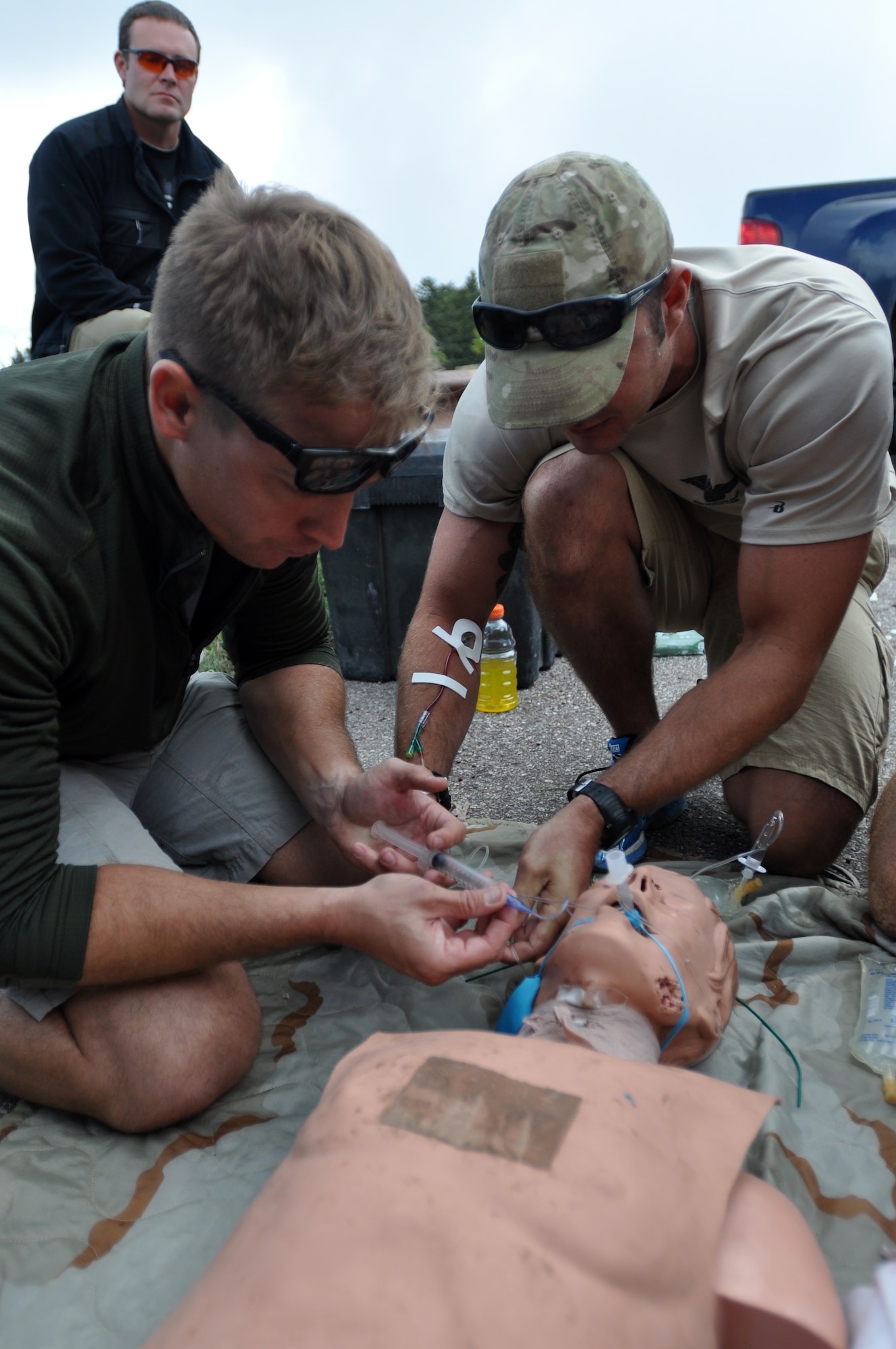 Two pararescuemen administer medical attention to simulated patient during the 2014 Guardian Angel Rodeo, Albuquerque, New Mexico, September 26, 2014. The rodeo, or competition, was a week-long event that tested the PJs on land navigation skills, high-angel rope rescues, survival techniques, medical skills, weapons operations and overall physical endurance. (U.S. Air Force photo/ Tech. Sgt. Katie Spencer)