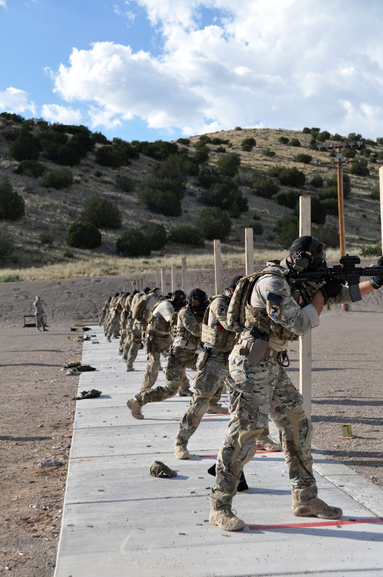 Pararescumen shoot their rifles while wearing gas masks as part of a shooting drill during the 2014 Guardian Angel Rodeo, Kirtland Air Force Base, New Mexico, September 24, 2014. The rodeo, or competition, was a week-long event that tested the PJs on land navigation skills, high-angel rope rescues, survival techniques, medical skills, weapons operations and overall physical endurance. (U.S. Air Force photo/ Tech. Sgt. Katie Spencer) 