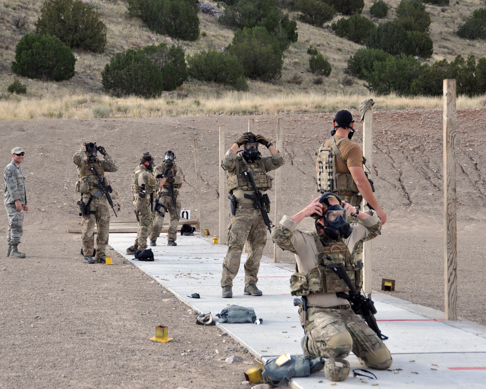 Pararesumen don their gas masks before a shooting drill during the 2014 Guardian Angel Rodeo, Kirtland Air Force Base, New Mexico, September 24, 2014. The rodeo, or competition, was a week-long event that tested the PJs on land navigation skills, high-angel rope rescues, survival techniques, medical skills, weapons operations and overall physical endurance. (U.S. Air Force photo/ Tech. Sgt. Katie Spencer)  