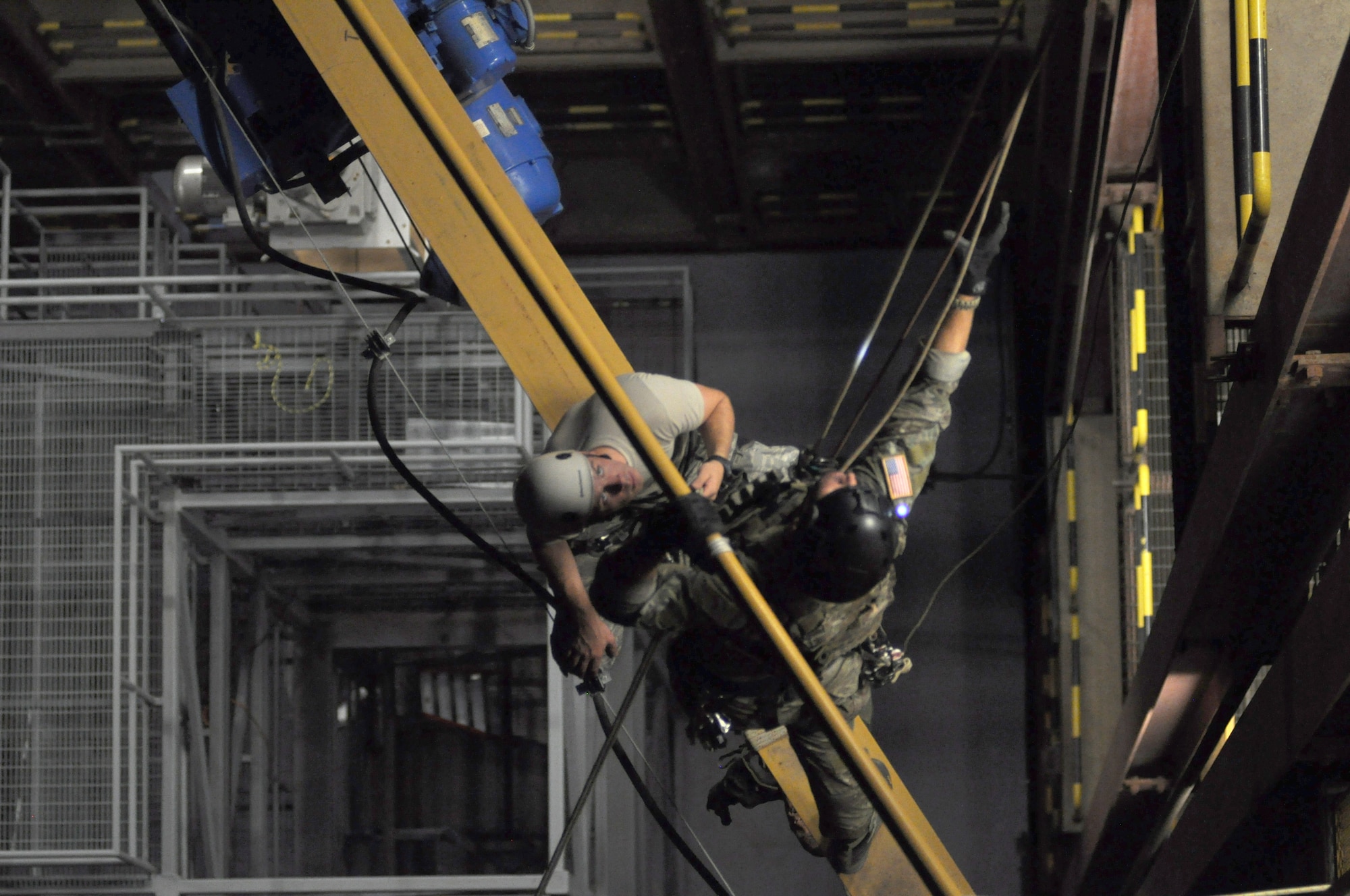 A pararescuman attaches a safety harness to a simulated victim five floors above the ground s part of a high-angel rescue during the 2014 Guardian Angel Rodeo, Kirtland Air Force Base, New Mexico, September 24, 2014. The rodeo, or competition, was a week-long event that tested the PJs on land navigation skills, high-angel rope rescues, survival techniques, medical skills, weapons operations and overall physical endurance. (U.S. Air Force photo/ Tech. Sgt. Katie Spencer)  