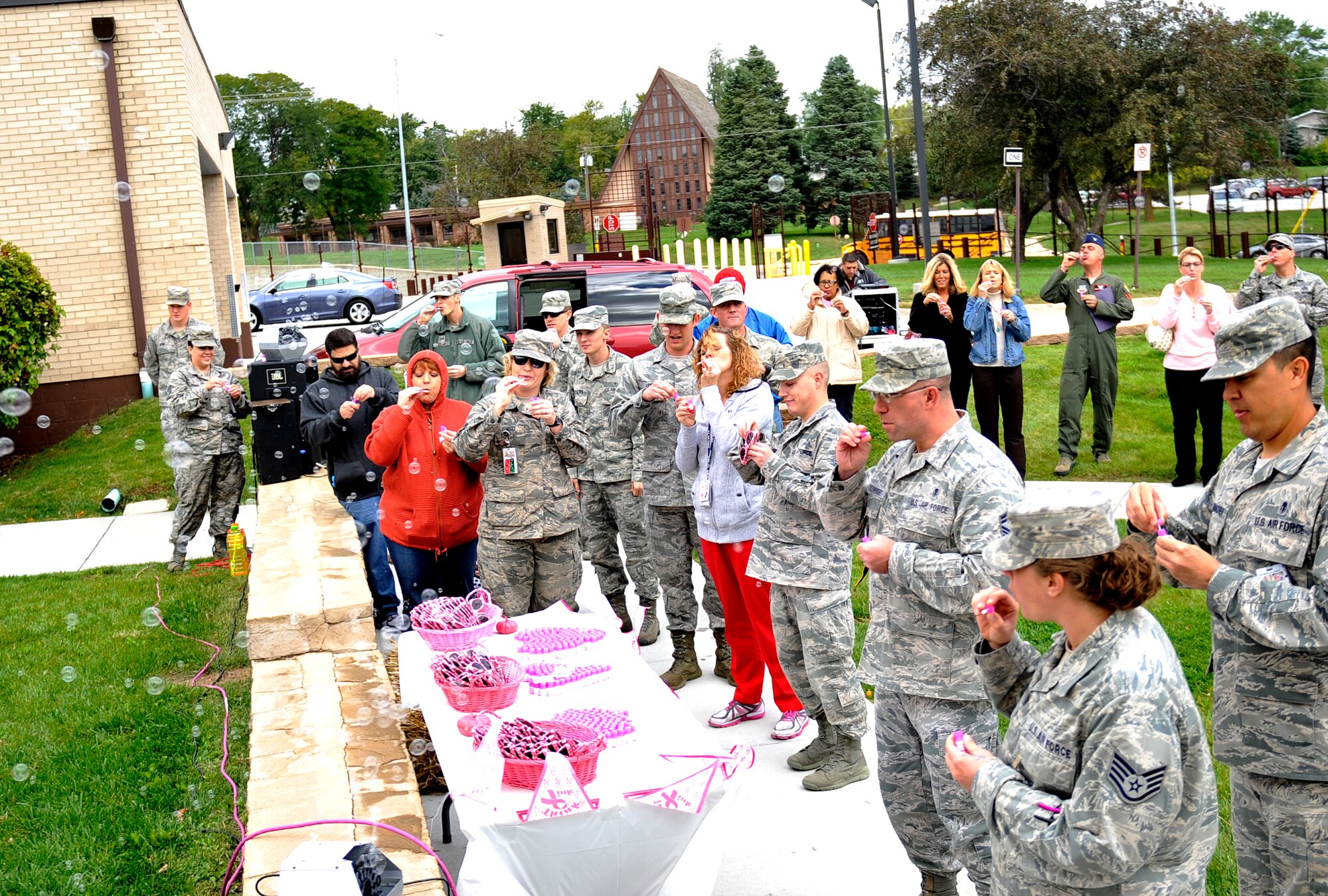 Members of Team Offutt blow bubbles during the Blow Away Breast Cancer event Oct. 3 on the front lawn of the Ehrling Bergquist clinic. One in eight women will be diagnosed with breast cancer in their lifetime. (U.S. Air Force photo by Jeff W. Gates)