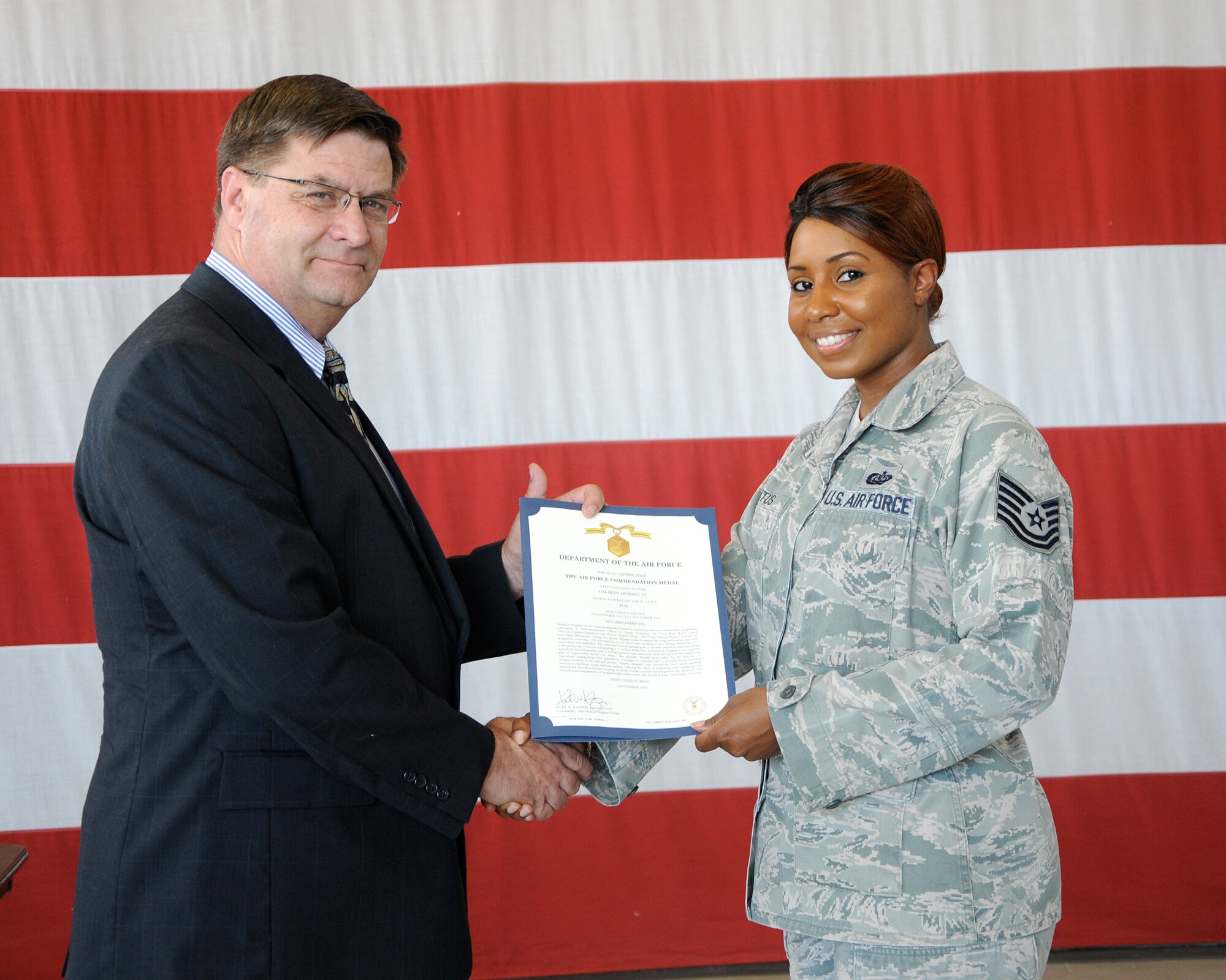 Tech. Sgt. Jeri Catus, former Columbus Air Force Base Honor Guard NCO In Charge, receives a Commendation Medal Oct. 1 from Michael Sampson, 14th Force Support Squadron Director, for her dedication to the Base Honor Guard. Catus served as NCOIC of the Base Honor Guard from October 2013-2014. (U.S. Air Force photo/Melissa Doublin)