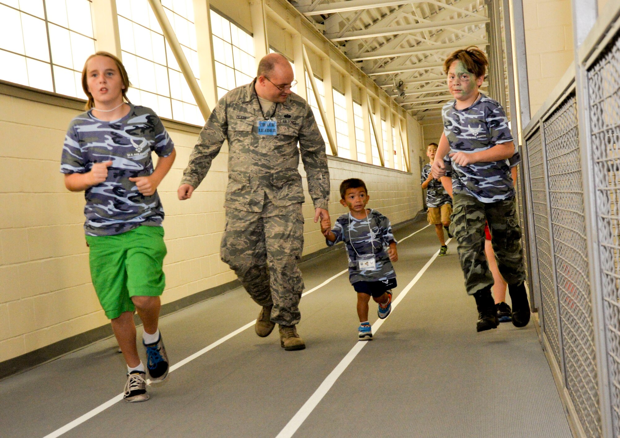 Tech. Sgt. Gregory Clark, Air Force Global Strike Command voice and data specialist, runs with Operation Hero participants during a mock physical fitness test on Barksdale Air Force Base, La., Sept. 27, 2014. During the mock fitness test participants performed sit-ups, push-ups and running. (U.S. Air Force photo/Airman 1st Class Mozer O. Da Cunha)