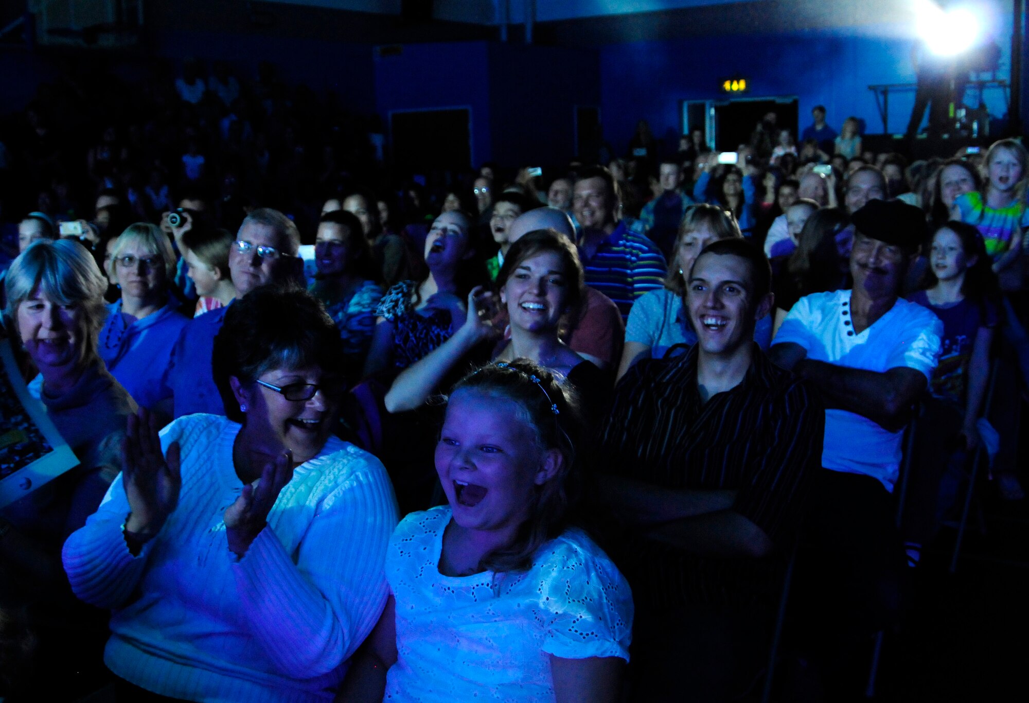 Audience members show their excitement during a version of the song “Let it Go,” from the movie “Frozen,” during a Tops in Blue concert Oct. 1, 2014, on RAF Mildenhall, England. The U.S. Air Force’s premier entertainment group performed a wide variety of songs and had audience members singing and dancing during the show. (U.S. Air Force photo/Karen Abeyasekere/Released)