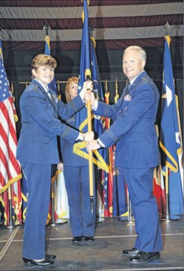Gen. Janet Wolfenbarger, Air Force Materiel Command commander, passes the Air Force Life Cycle Management Center flag to Lt. Gen. John Thompson in a ceremony at the National Museum of the U.S. Air Force on Sept. 26. Thompson officially assumed command of AFLCMC on Oct. 2. (Air Force photo Al Bright)