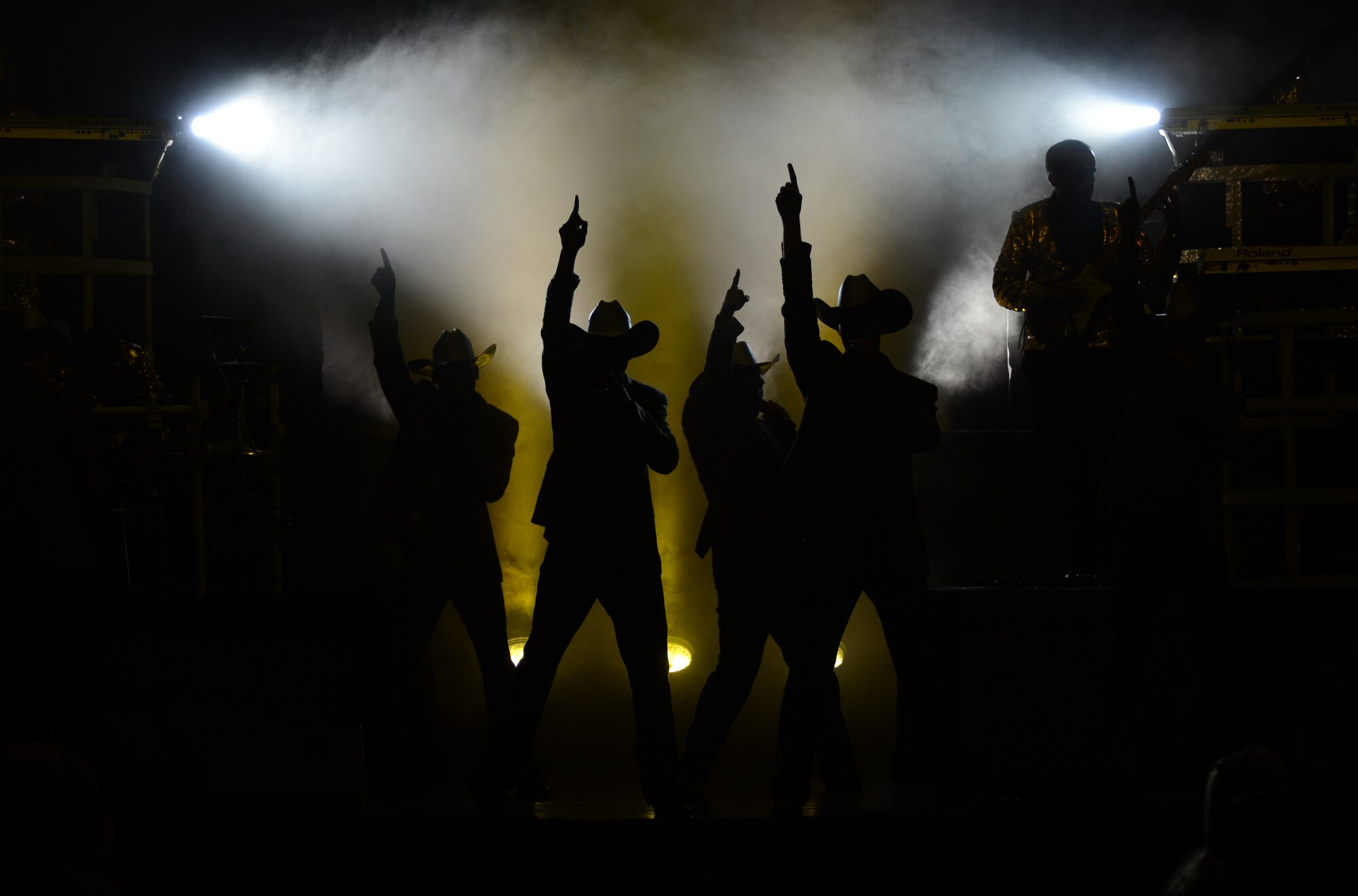 Tops in Blue members pose after finishing the country portion of their performance at the Northside Fitness Center Oct. 1, 2014, on RAF Mildenhall, England. Throughout the show, the performers wore a multitude of costumes to match the era and genre of music they sang. (U.S. Air Force photo/Airman 1st Class Dillon Johnston/Released)