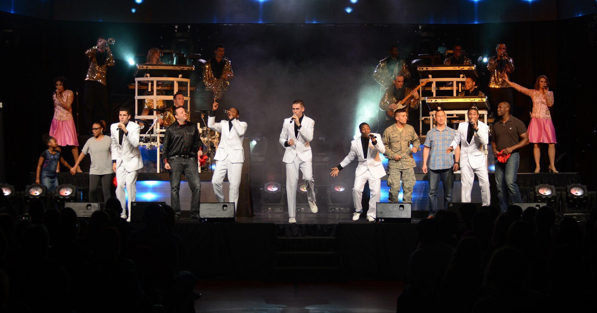 Team Mildenhall and Tops in Blue members perform at the Northside Fitness Center Oct. 1, 2014, on RAF Mildenhall, England. The Tops in Blue performers invited attendees from the crowd to sing with them on stage for a portion of the show. (U.S. Air Force photo/Airman 1st Class Dillon Johnston/Released)