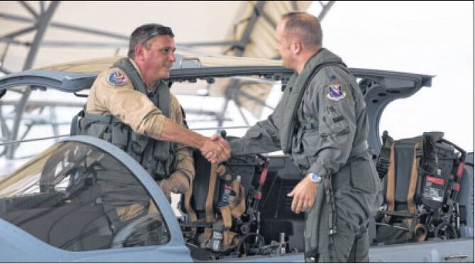 Chris Carlson, left, Sierra Nevada Corp. senior pilot, shakes hands with U.S. Air Force Lt. Col. Jeffery Hogan, Afghan A-29 Light Air Support training unit commander, after landing an A-29 Super Tucano for its first arrival Sept. 26 at Moody Air Force Base, Ga. Moody was selected for the A-29 LAS training mission to train a total of 30 Afghan pilots and 90 Afghan maintainers over the next four years.  (Air Force photo Airman 1st Class Dillian Bamman)