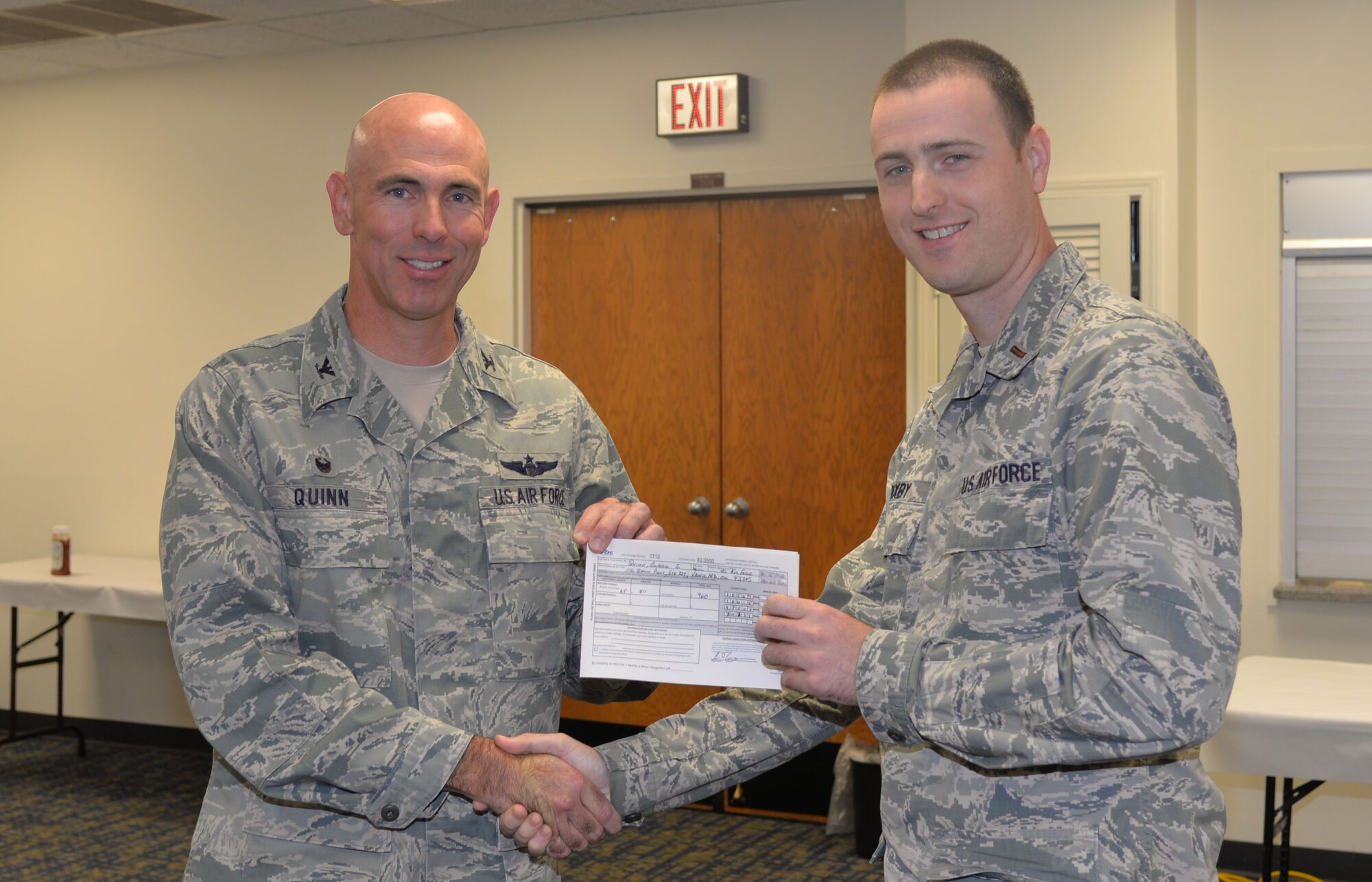 VANCE AIR FORCE BASE, Okla. -- Col. Clark Quinn, the 71st Flying Training Wing commander, and 2nd Lt. Andrew Bixby, the Wing Staff Agencies Combined Federal Campaign representative, hold Quinn’s donation slip, during the CFC kick-off breakfast at the Community Chapel Activities Center Sept. 30. (U.S. Air Force photo/Senior Airman Frank Casciotta)